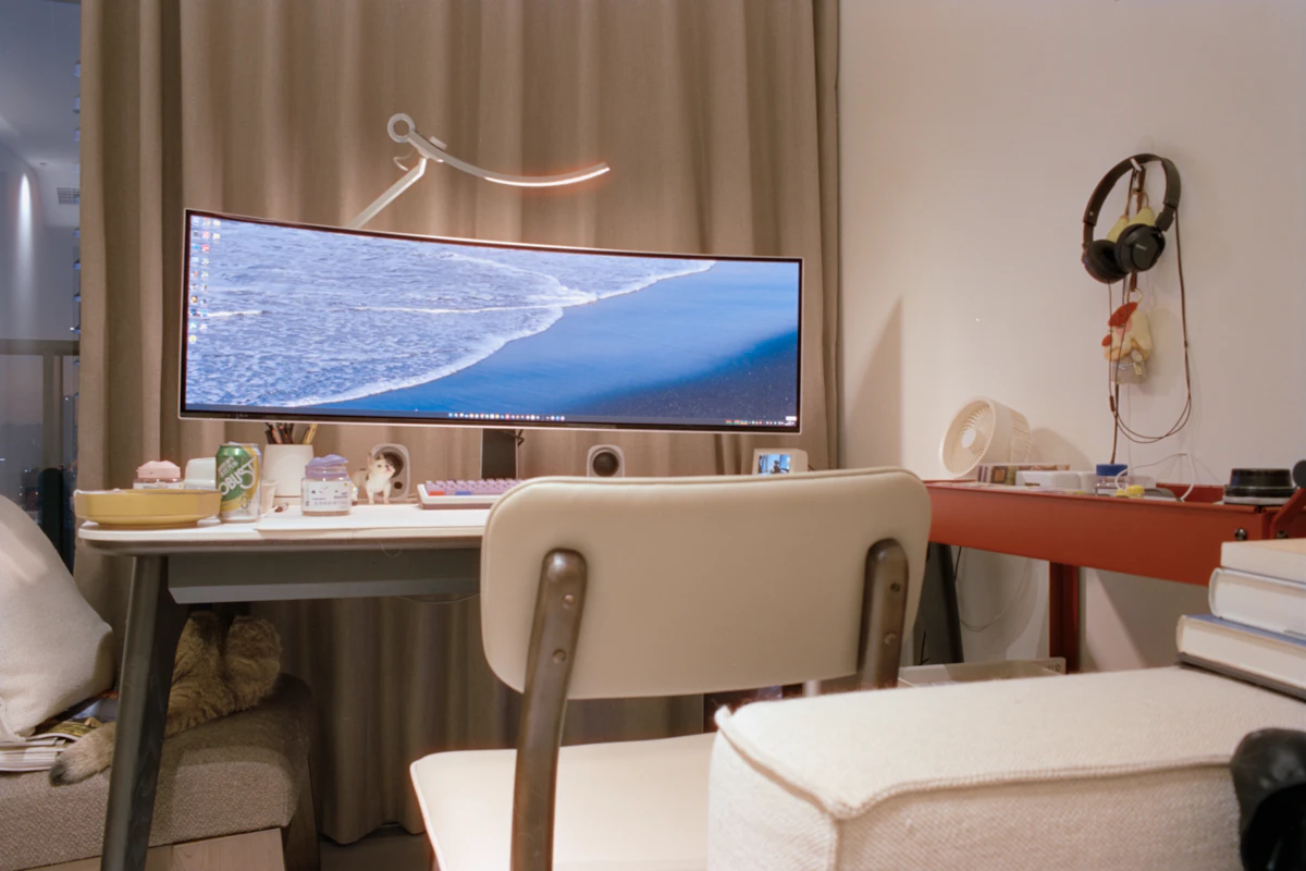 Curved monitor displaying ocean waves on a desk.