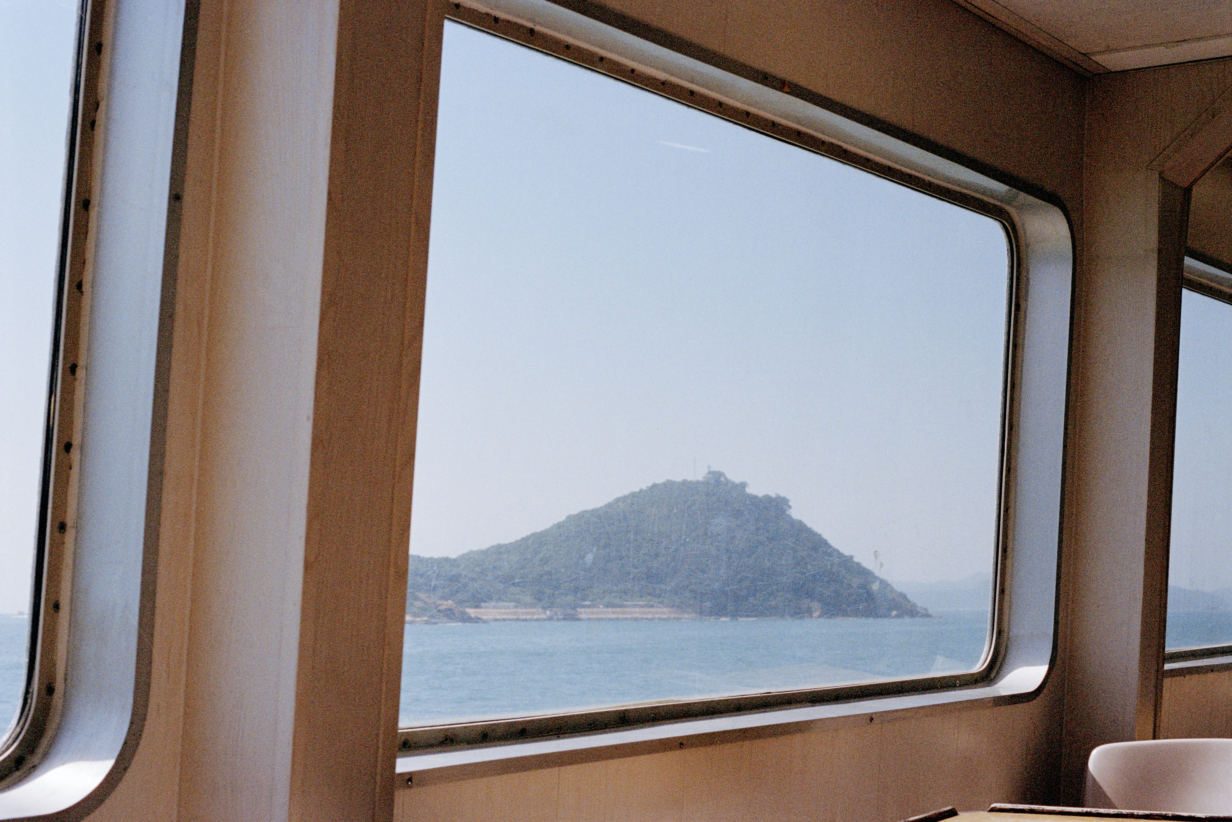 Island seen through a boat window on a clear day