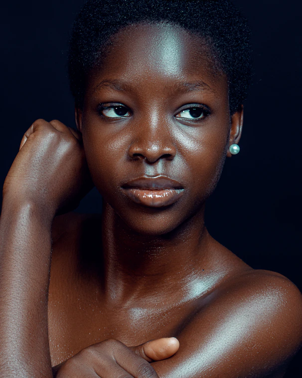 A young black woman with short hair gazes thoughtfully.