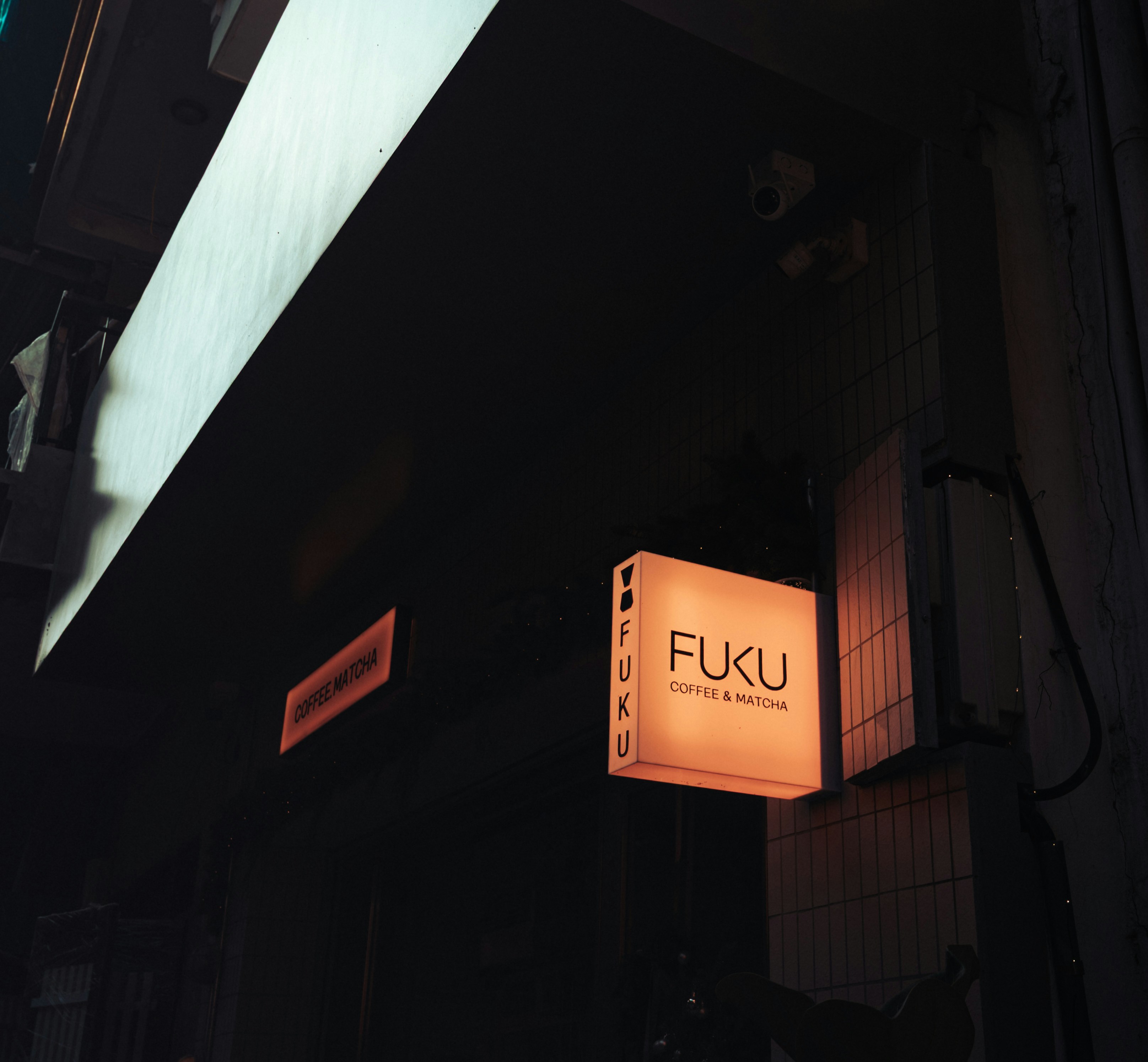 A glowing "fuku" sign on a dark building