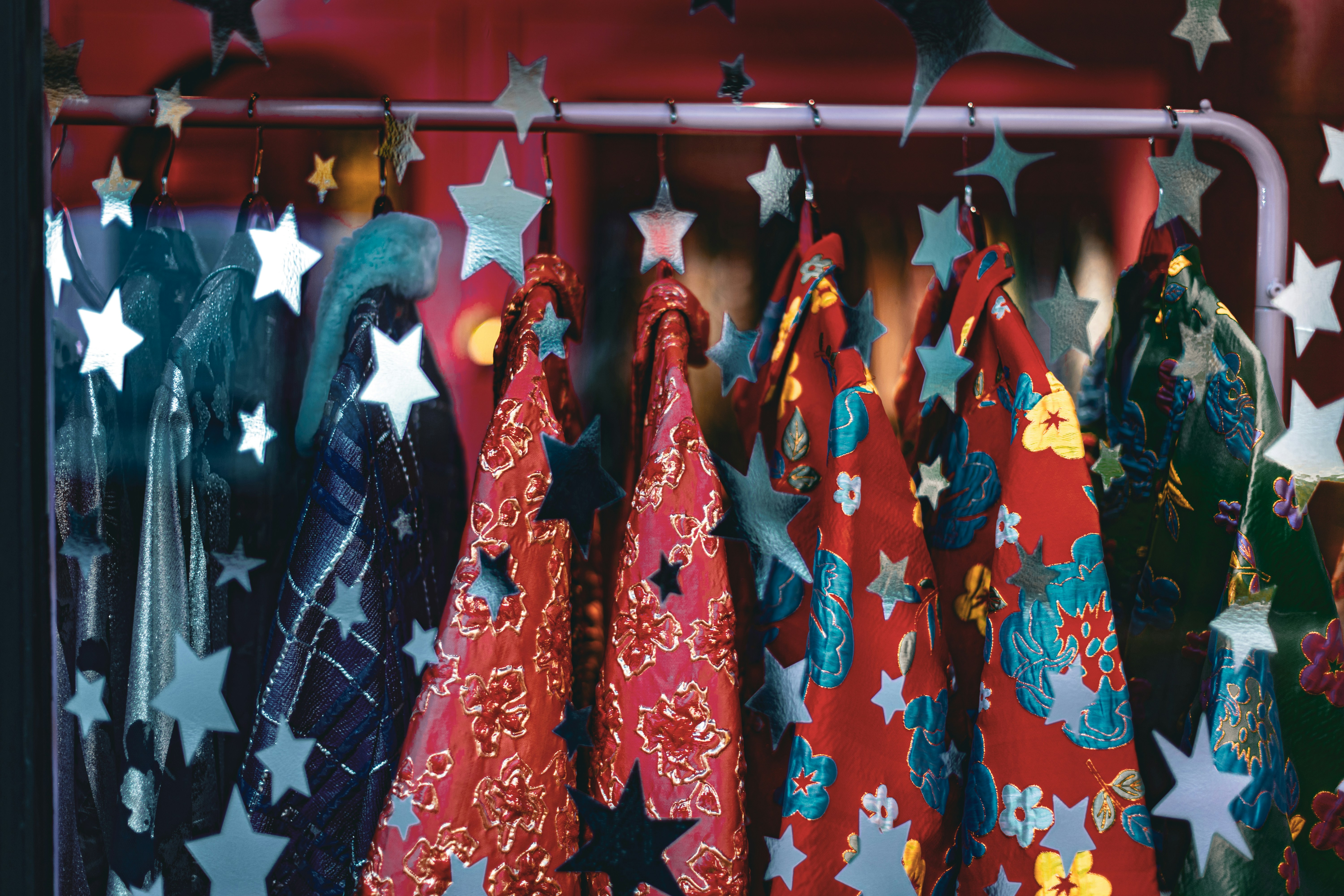 Colorful patterned fabrics hang on a rack with stars.