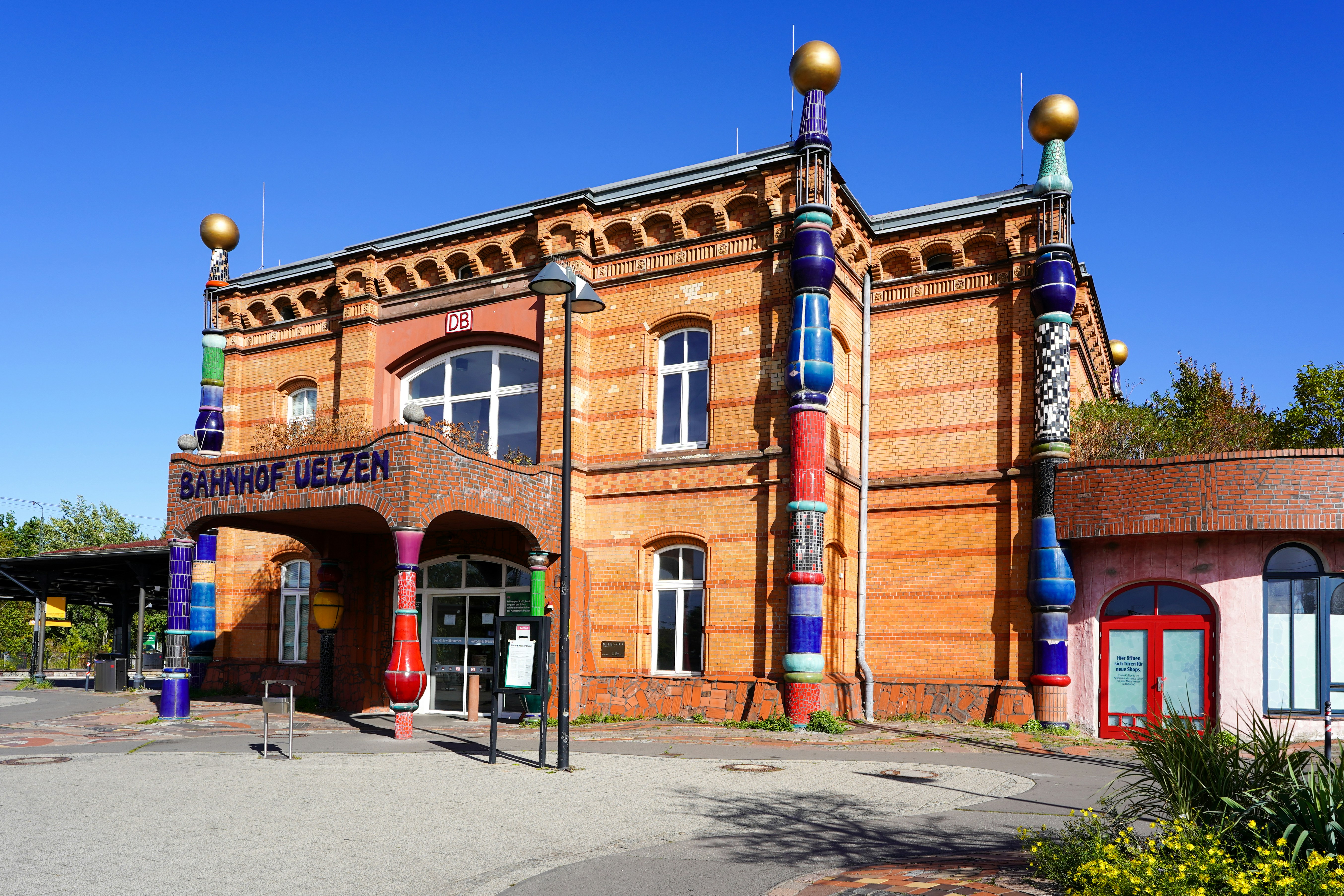 Ornate brick train station with colorful decorative columns.