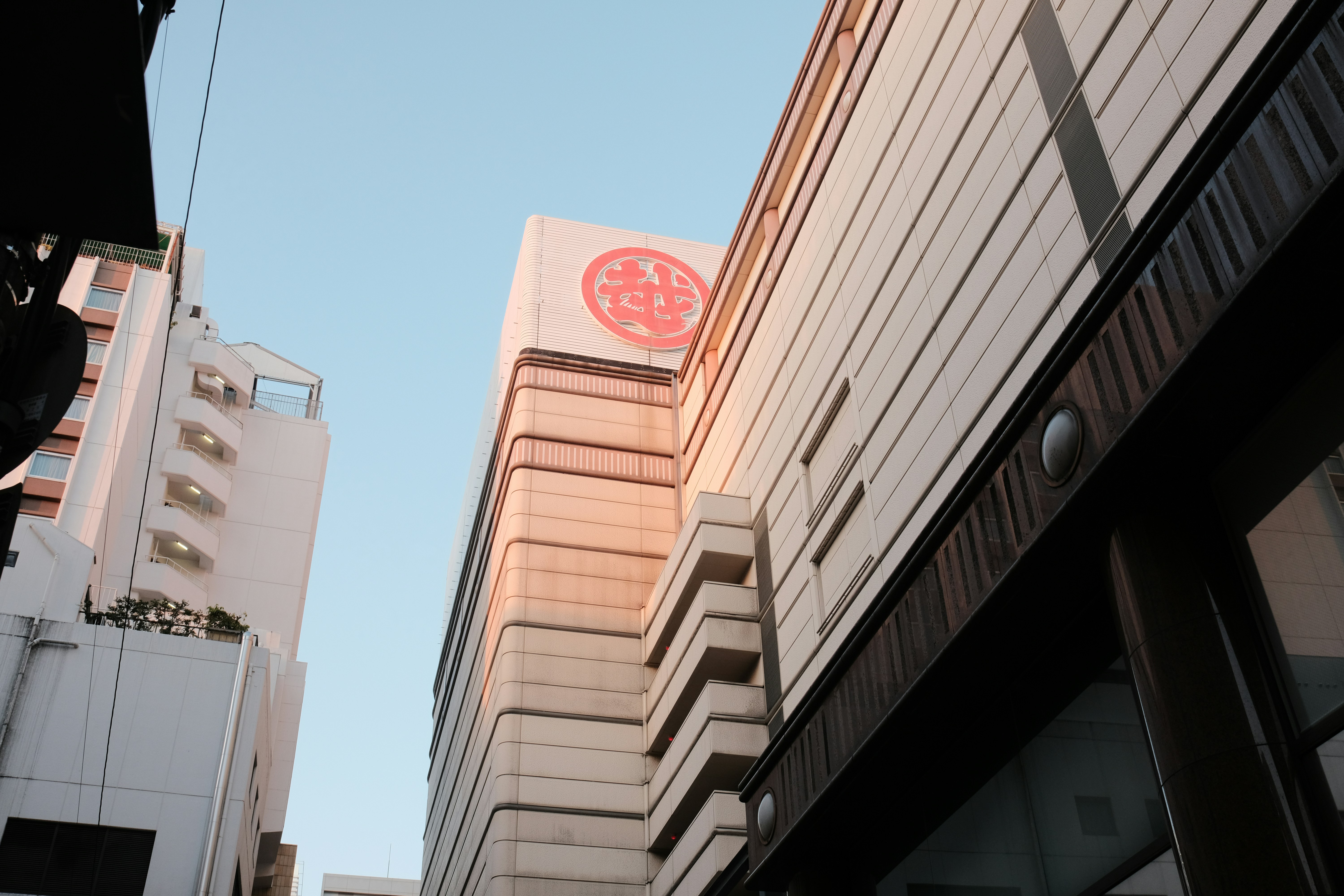 Modern building with a circular logo against blue sky