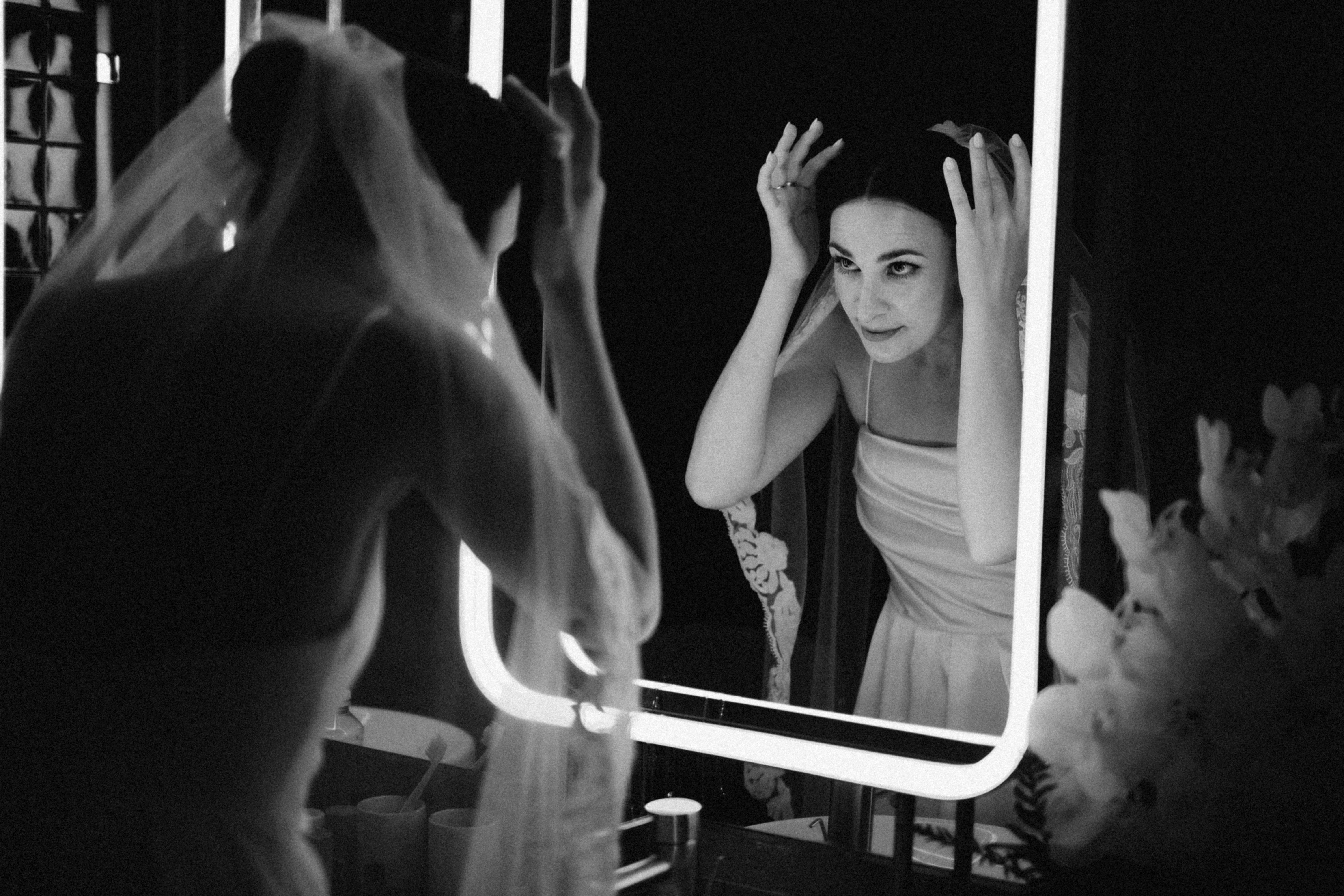 Bride adjusting veil in mirror
