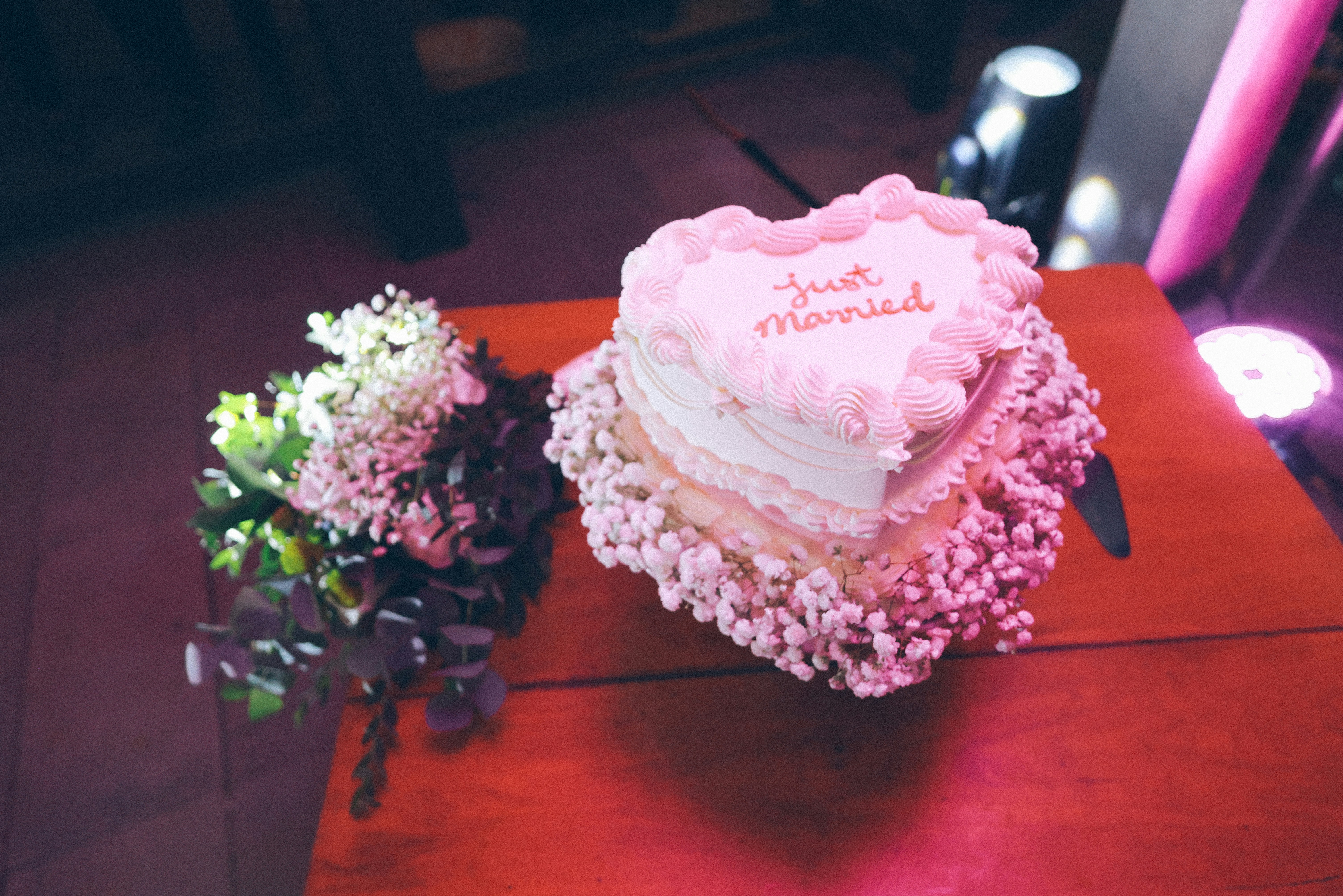 Gâteau en forme de cœur avec un texte « tout juste marié » et des fleurs