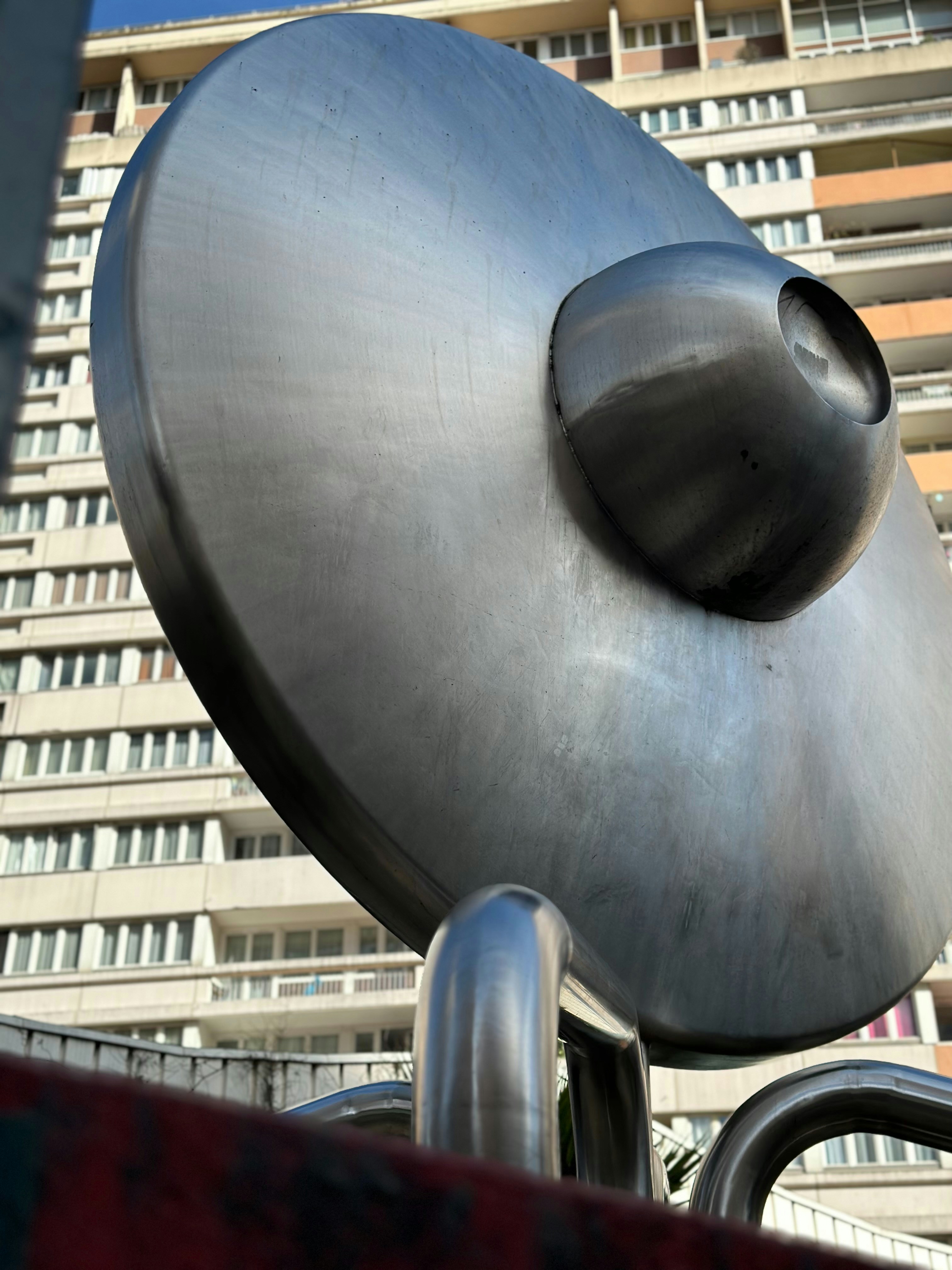 Large metal sculpture in front of apartment buildings