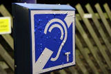 Blue sign with an ear symbol and water droplets.