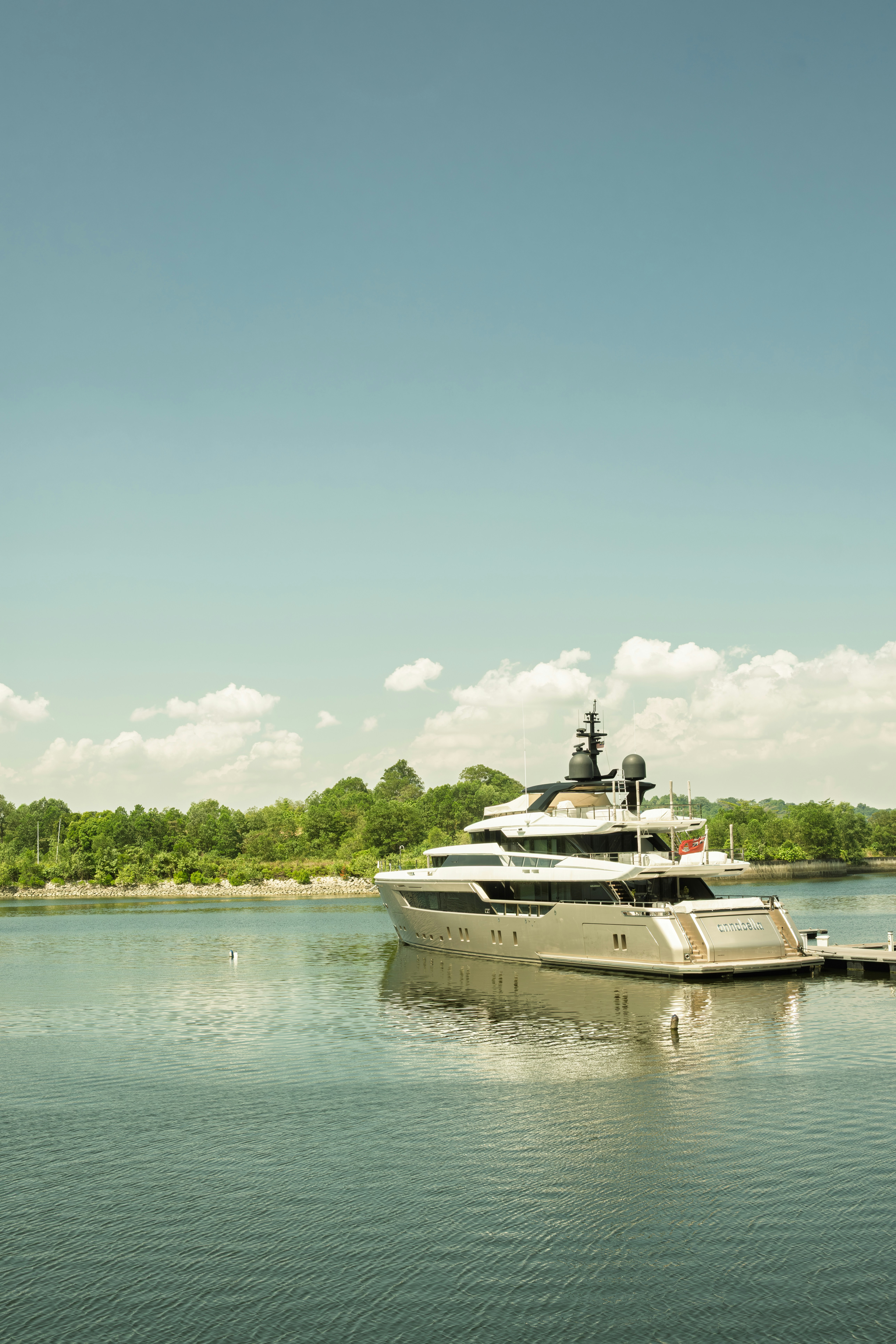 A large luxury yacht docked by a pier
