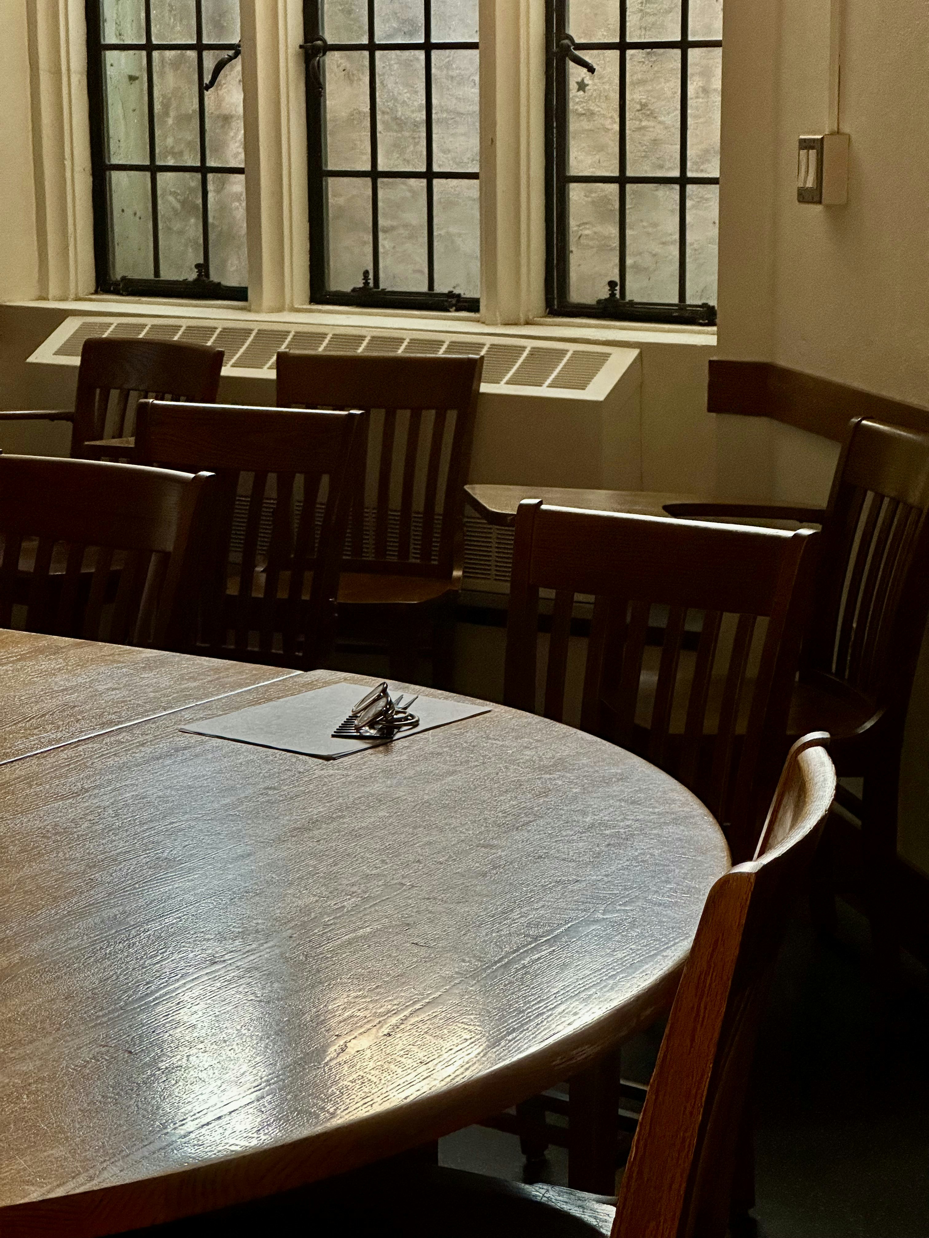Empty classroom with wooden chairs and table.