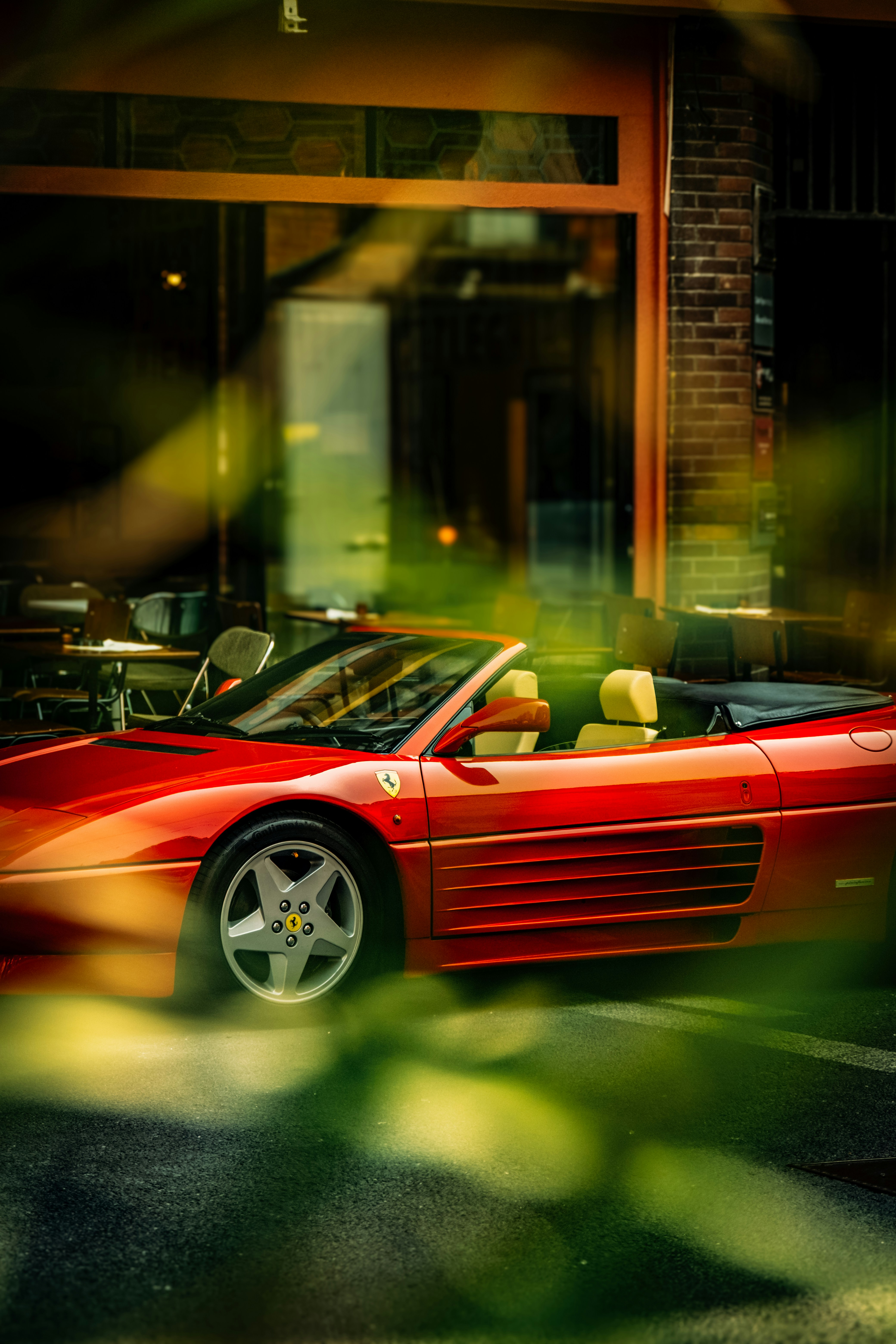 A red convertible sports car parked outside.