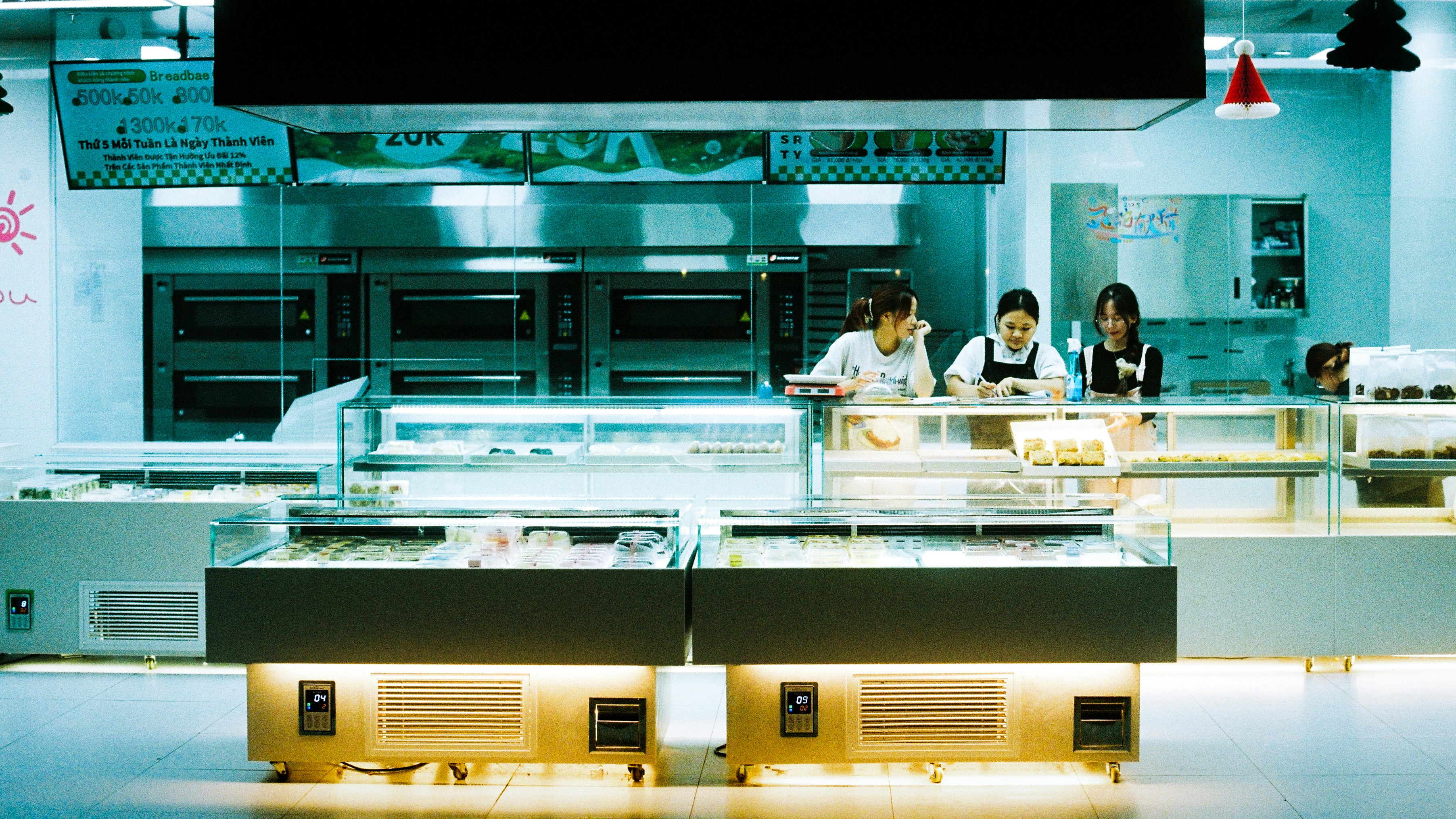 Workers behind counter in a modern bakery display