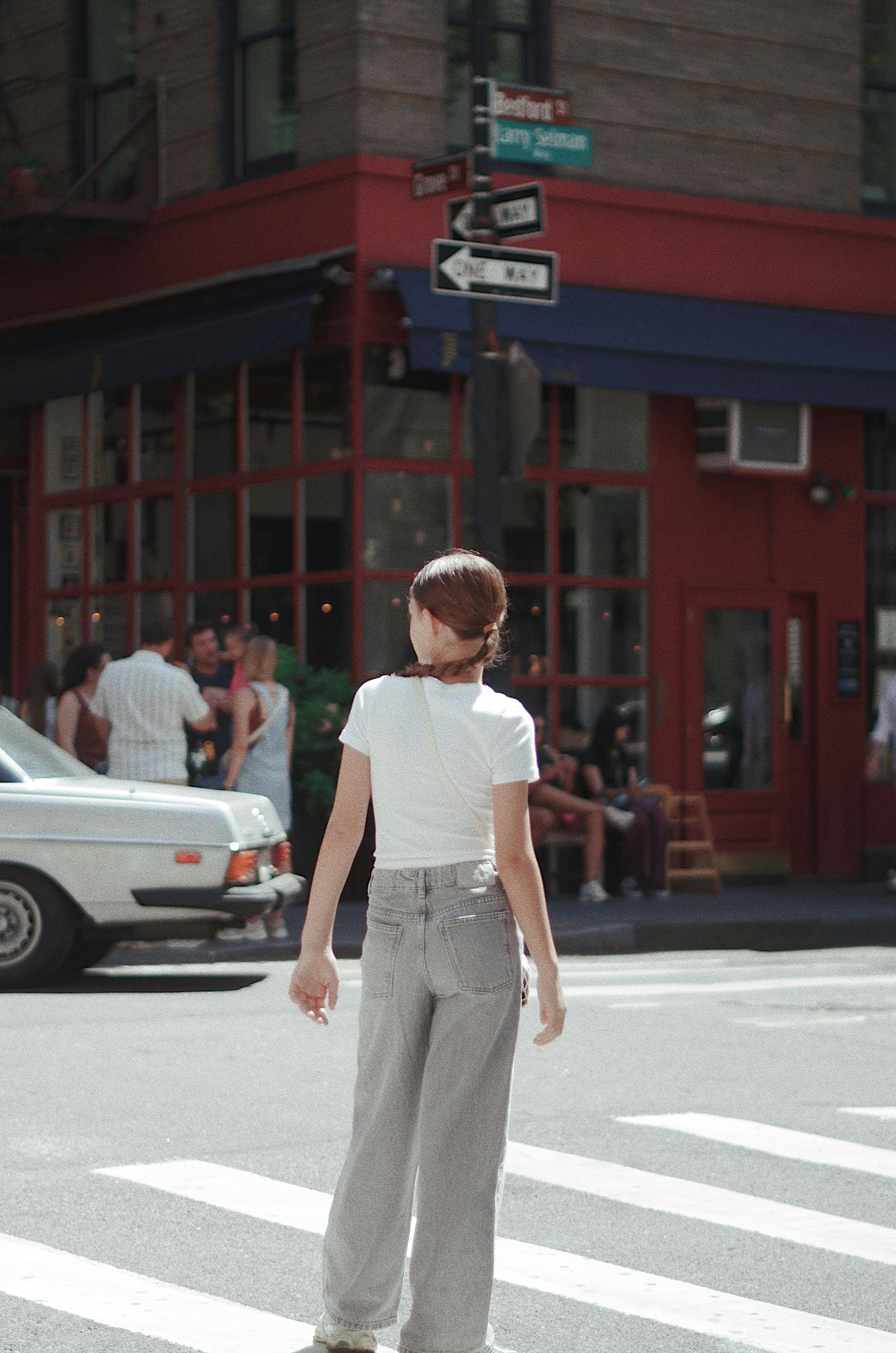 Frau steht an einer Straßenecke der Stadt.