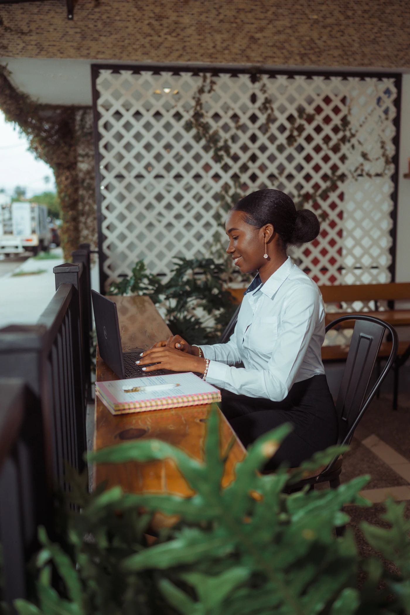Mujer sonriente trabajando en su laptop al aire libre