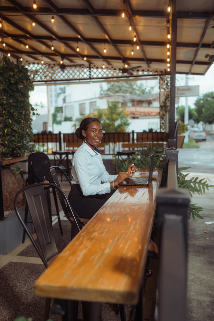 A woman working on a laptop at an outdoor café