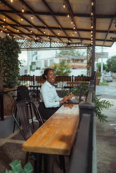 Small business owner working on laptop at outdoor café