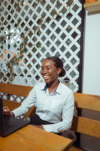 Young woman smiling while working on laptop