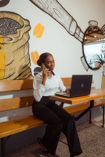 Woman talking on phone while working on laptop
