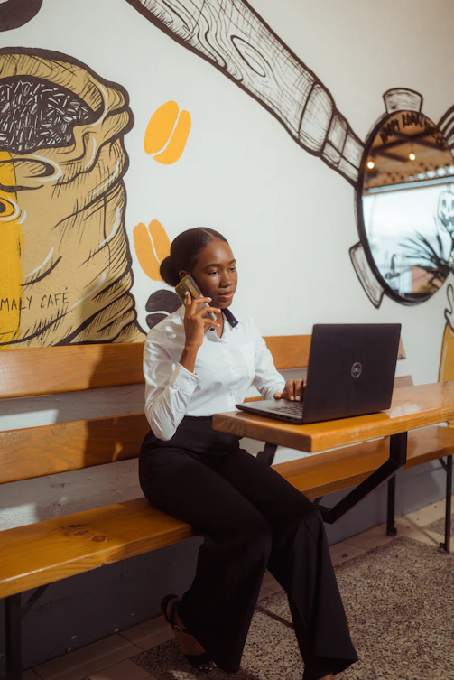 Woman talking on phone while working on laptop