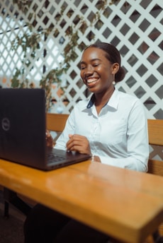 Young woman laughs while working on laptop