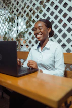Young woman smiling while working on a laptop
