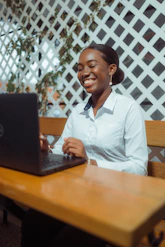 Young woman smiling while working on a laptop.