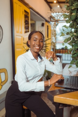 Young woman smiling at desk with laptop.