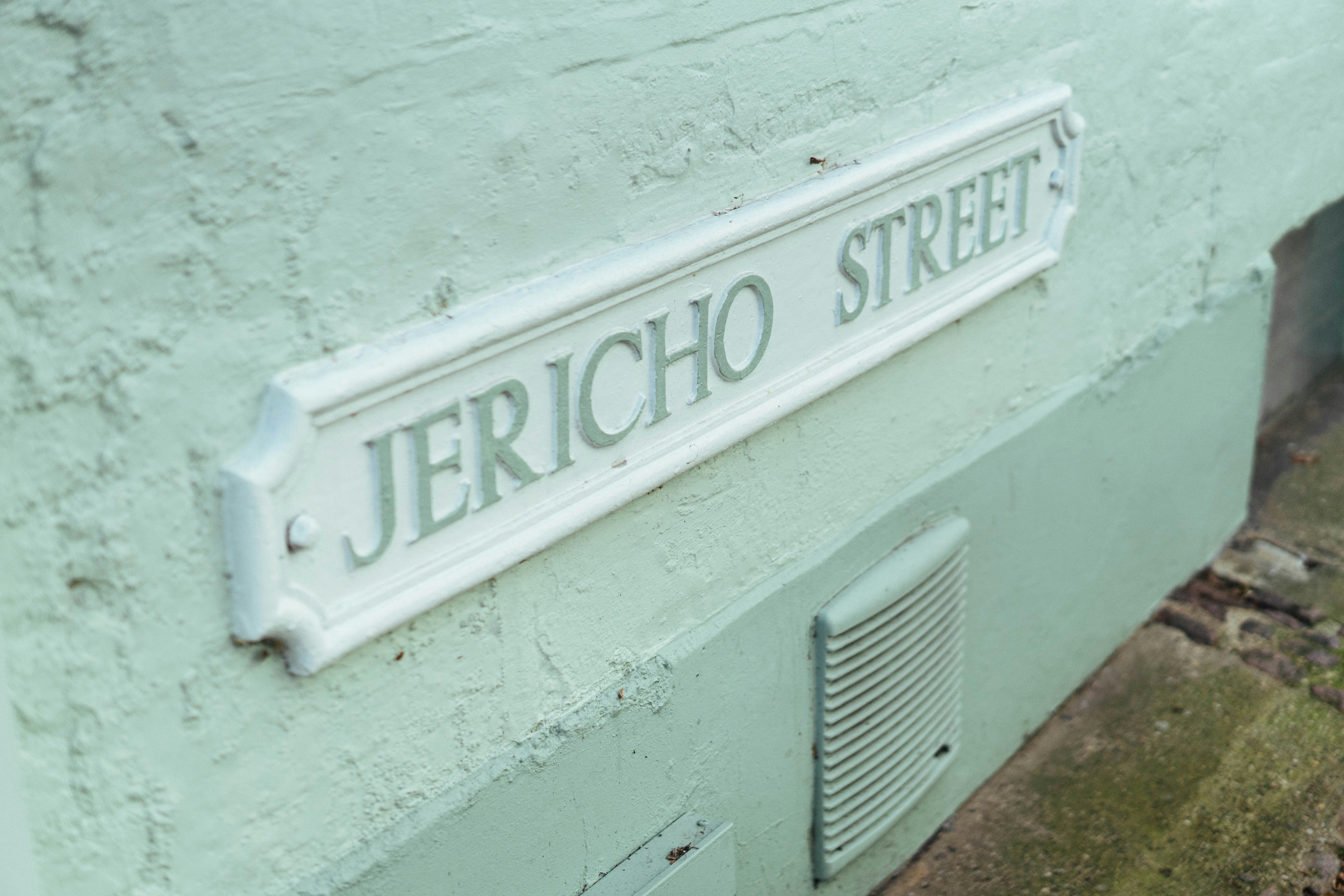 白の通りの標識には壁に「Jericho Street」と書かれています