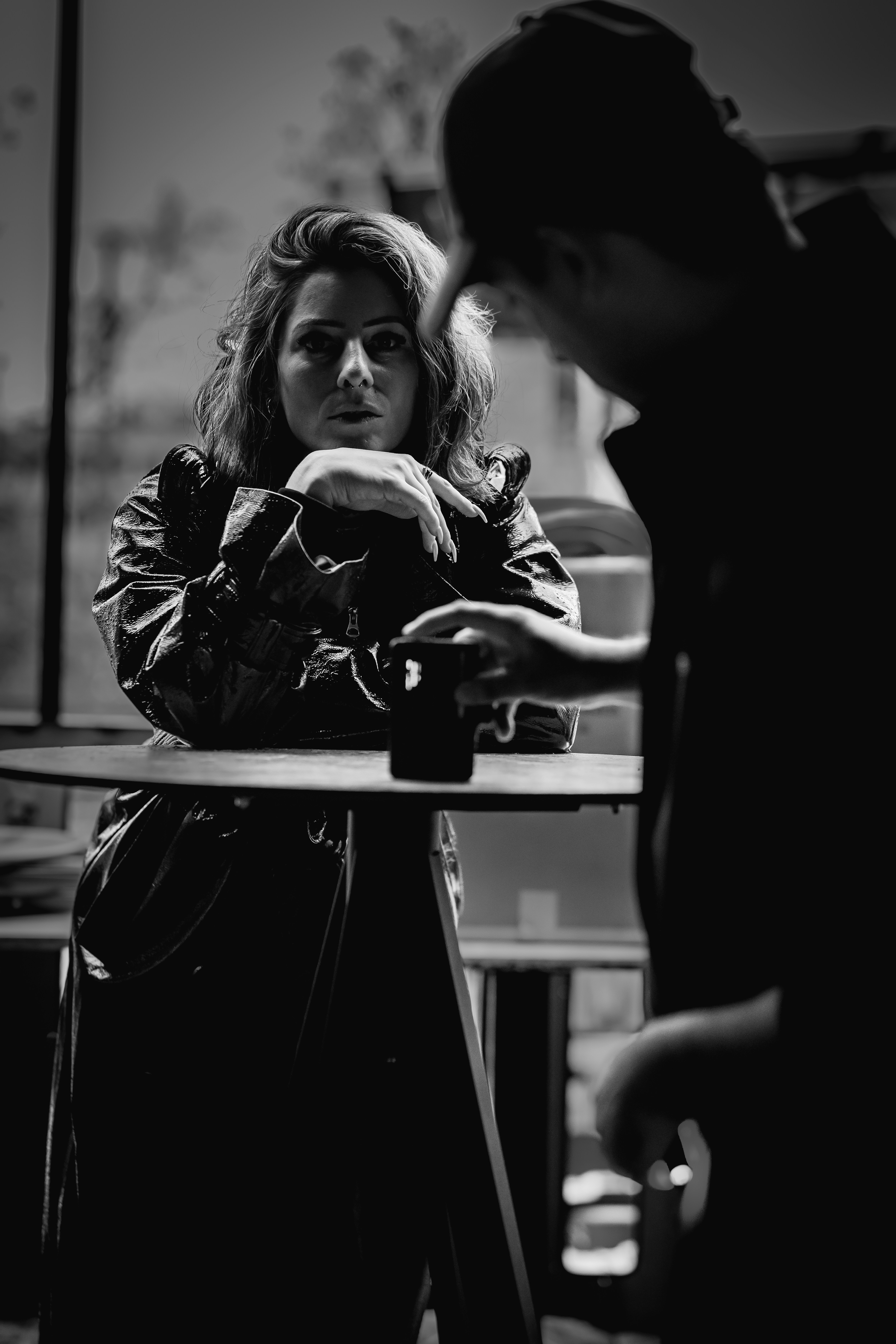 Zwei Menschen unterhalten sich an einem Tisch mit einem Getränk