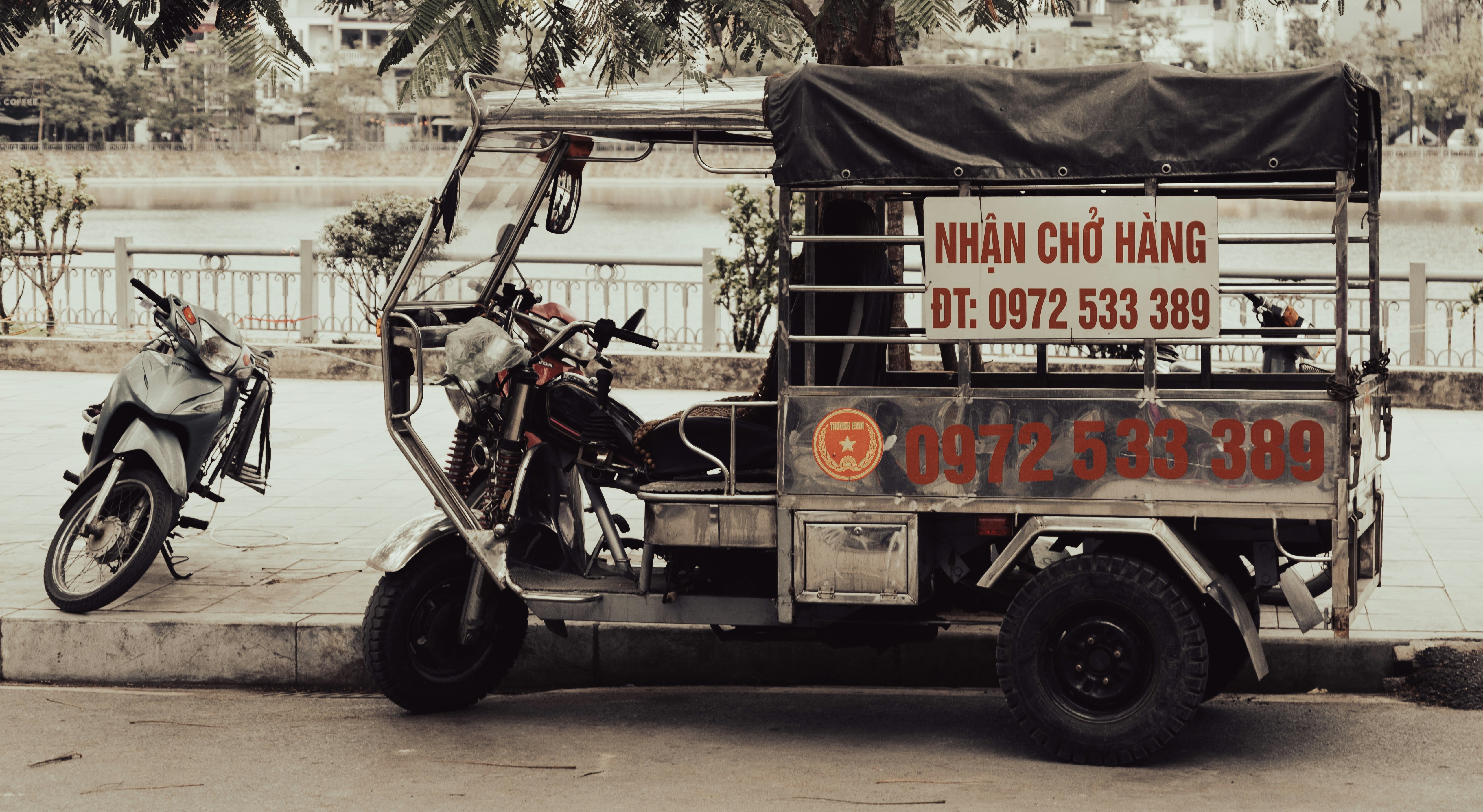 Three-wheeled vehicle with a covered cargo bed.