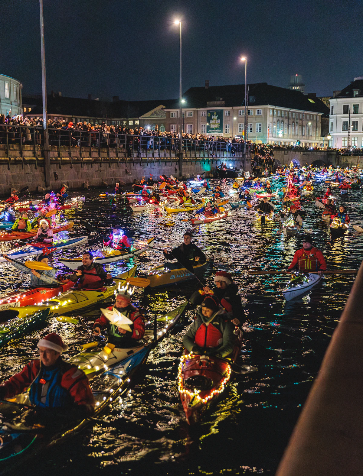 Kayaks iluminados en agua de noche