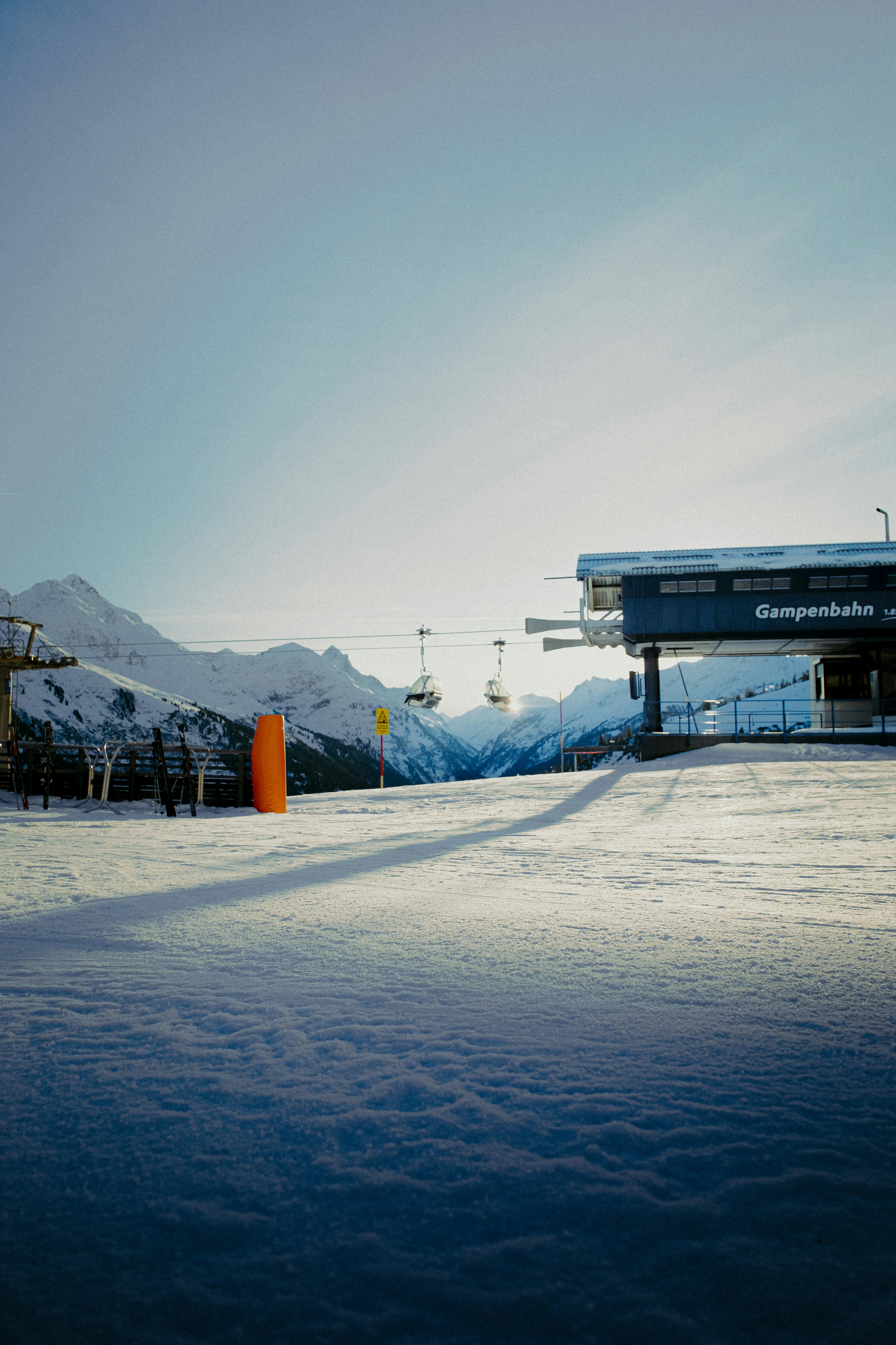 Ski lift station with snowy mountains in background.