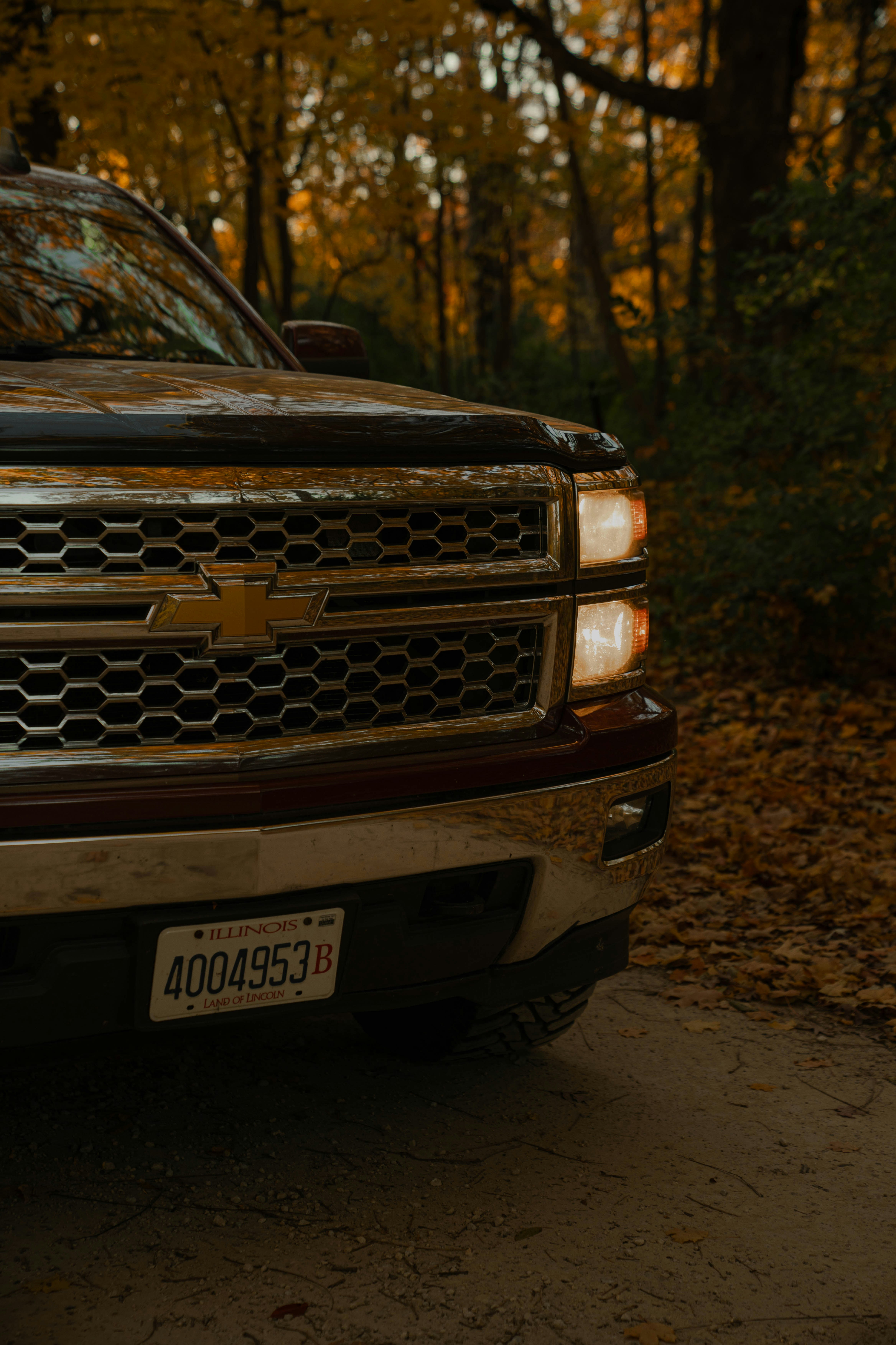 A dark pickup truck parked on a dirt road.