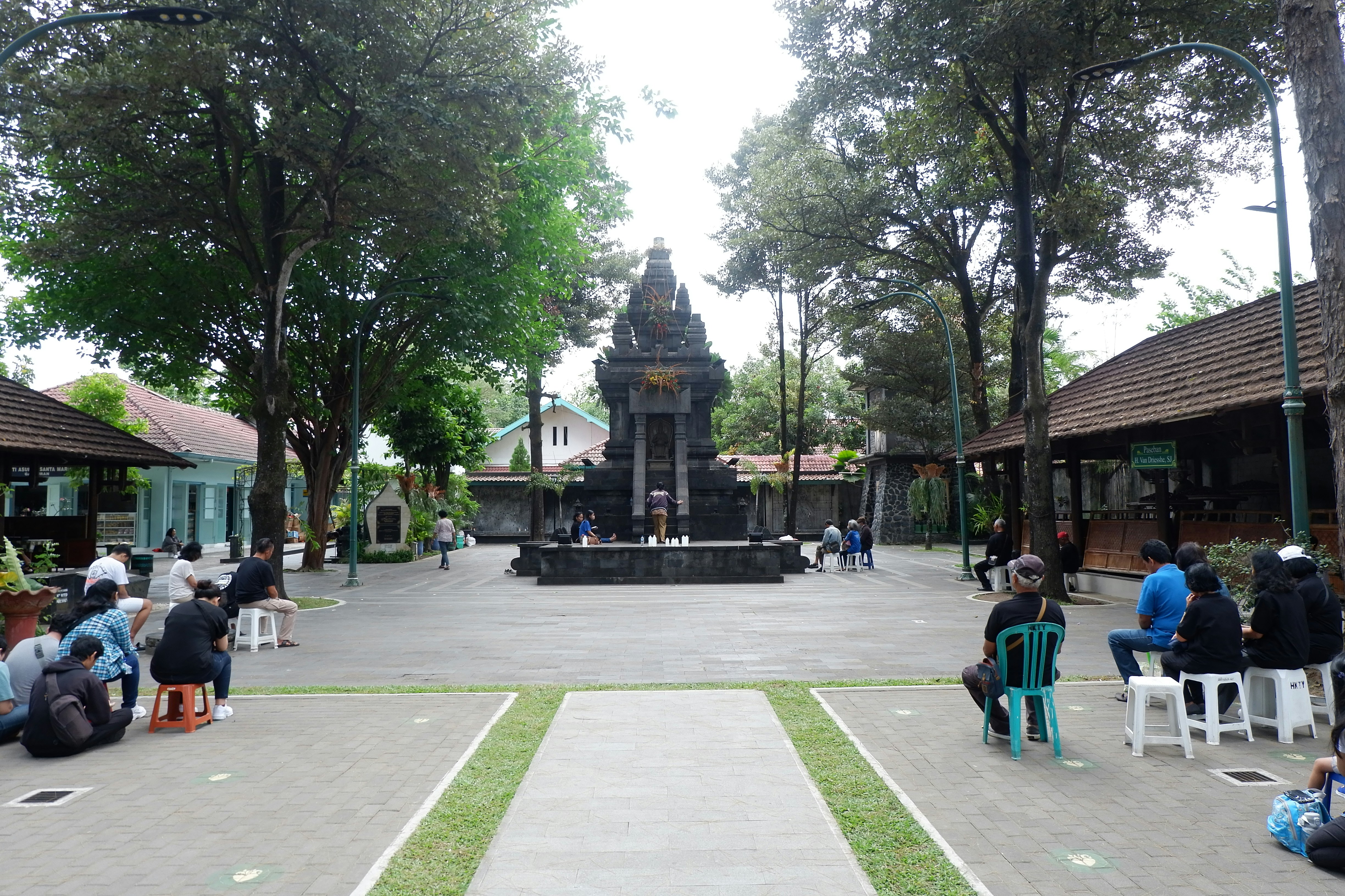 People gathered around a monument in a courtyard.