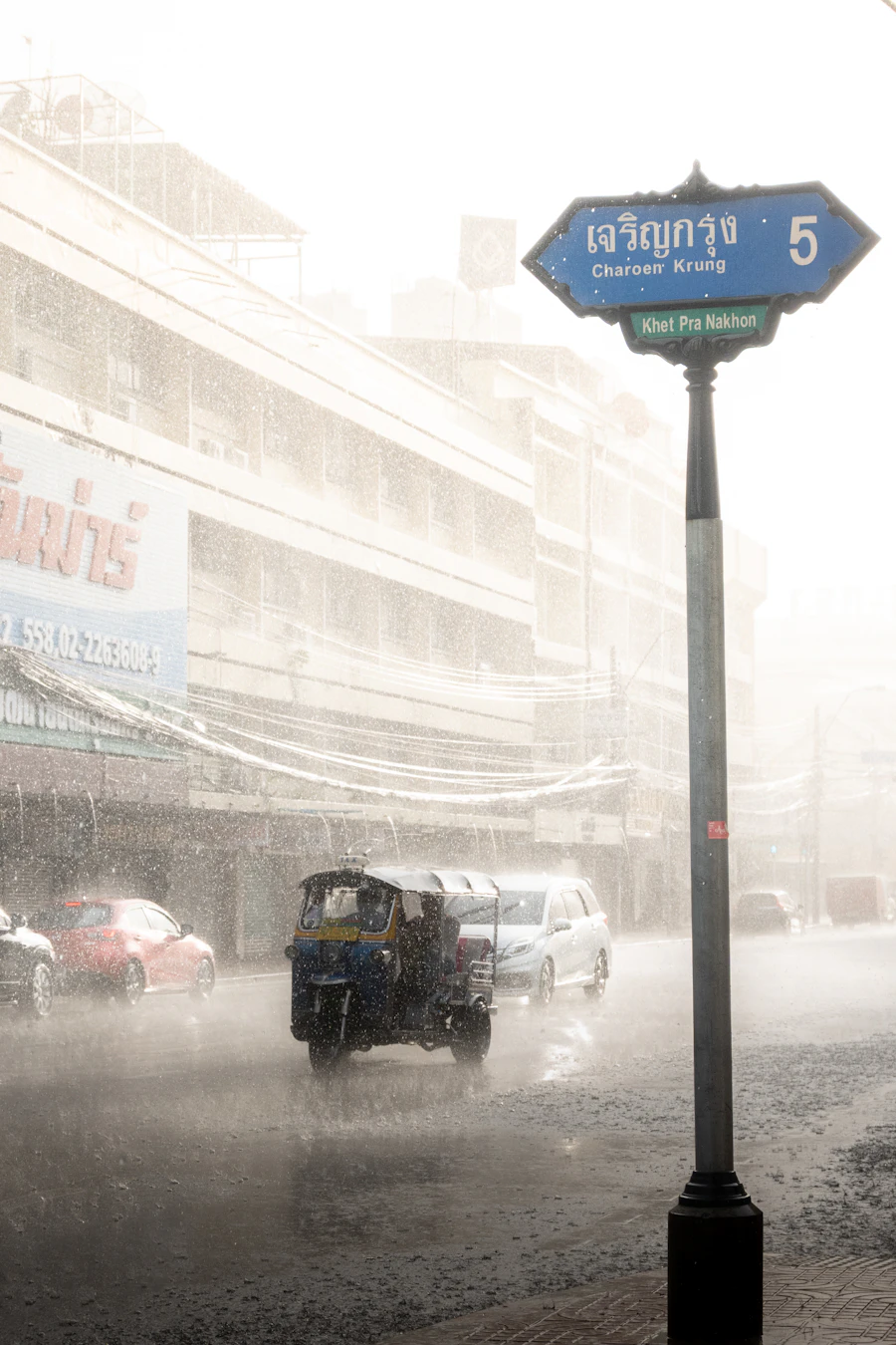 A tuk-tuk travelling in heavy rain