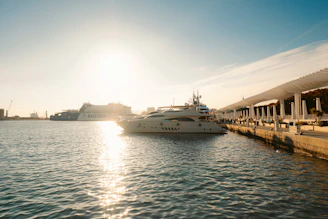 Luxury yachts docked at a harbor during sunset