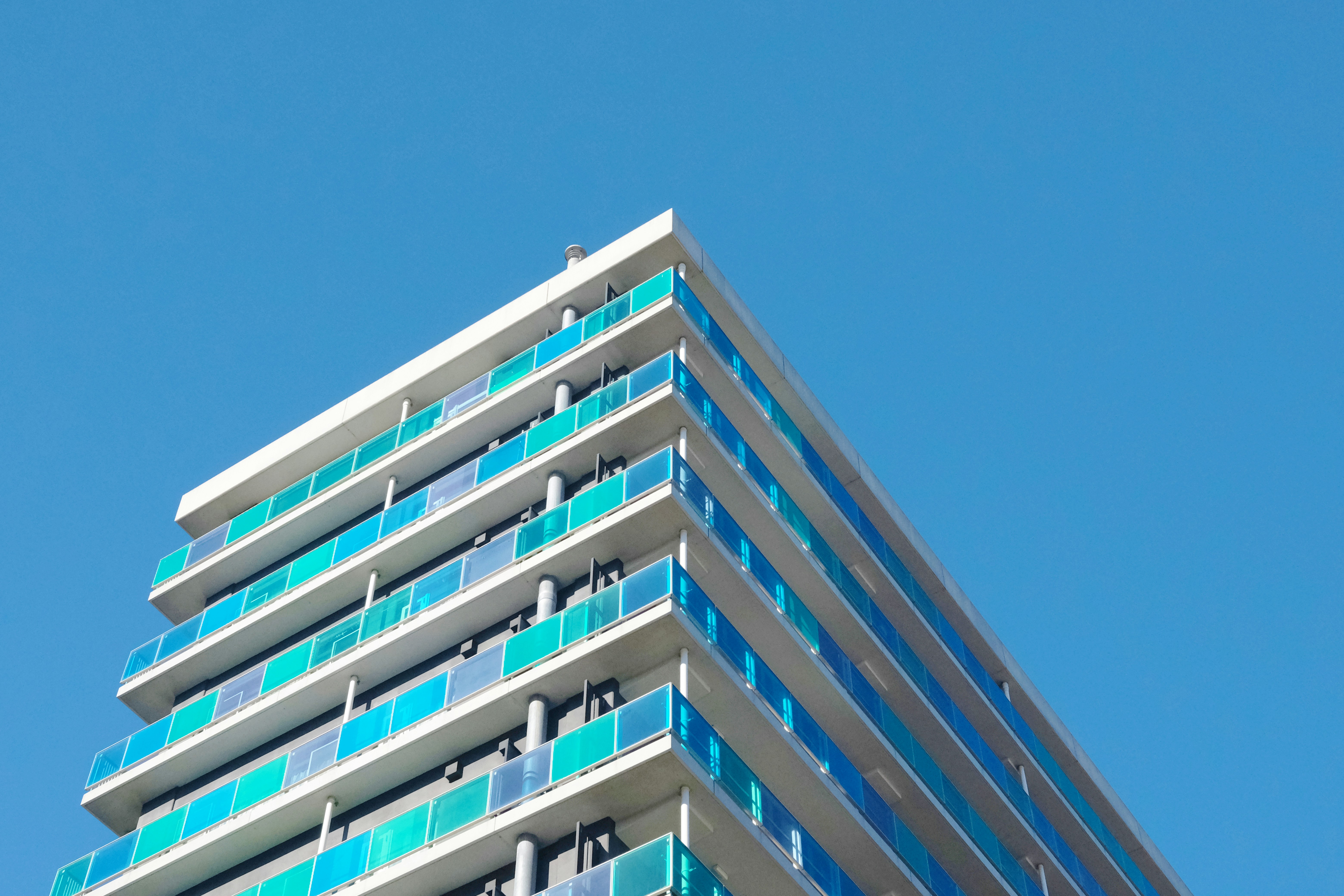 Edificio moderno con balcones azules contra cielo despejado