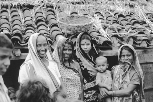 Group of women and child in front of tiled roof