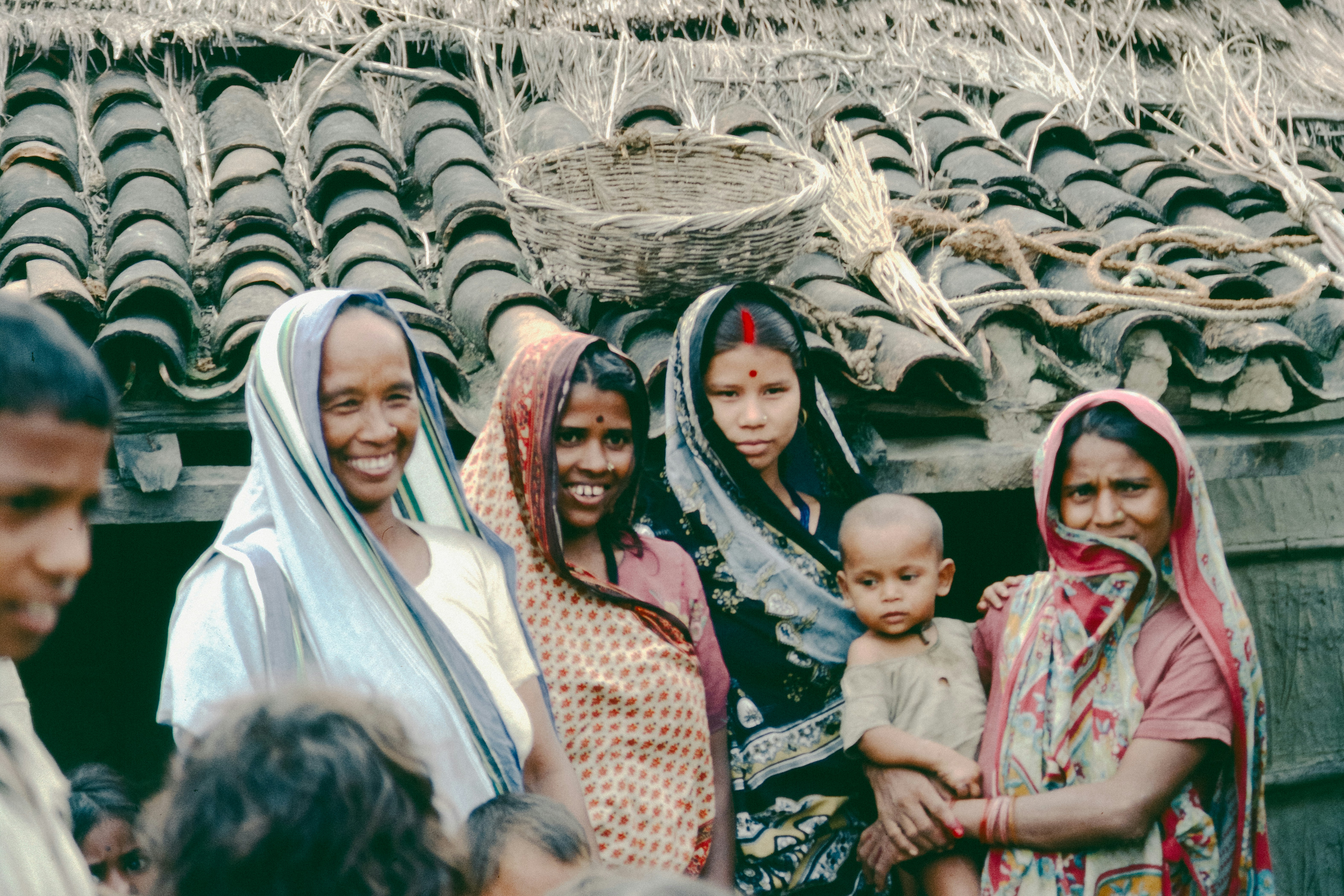 Group of people in traditional clothing outside a building.