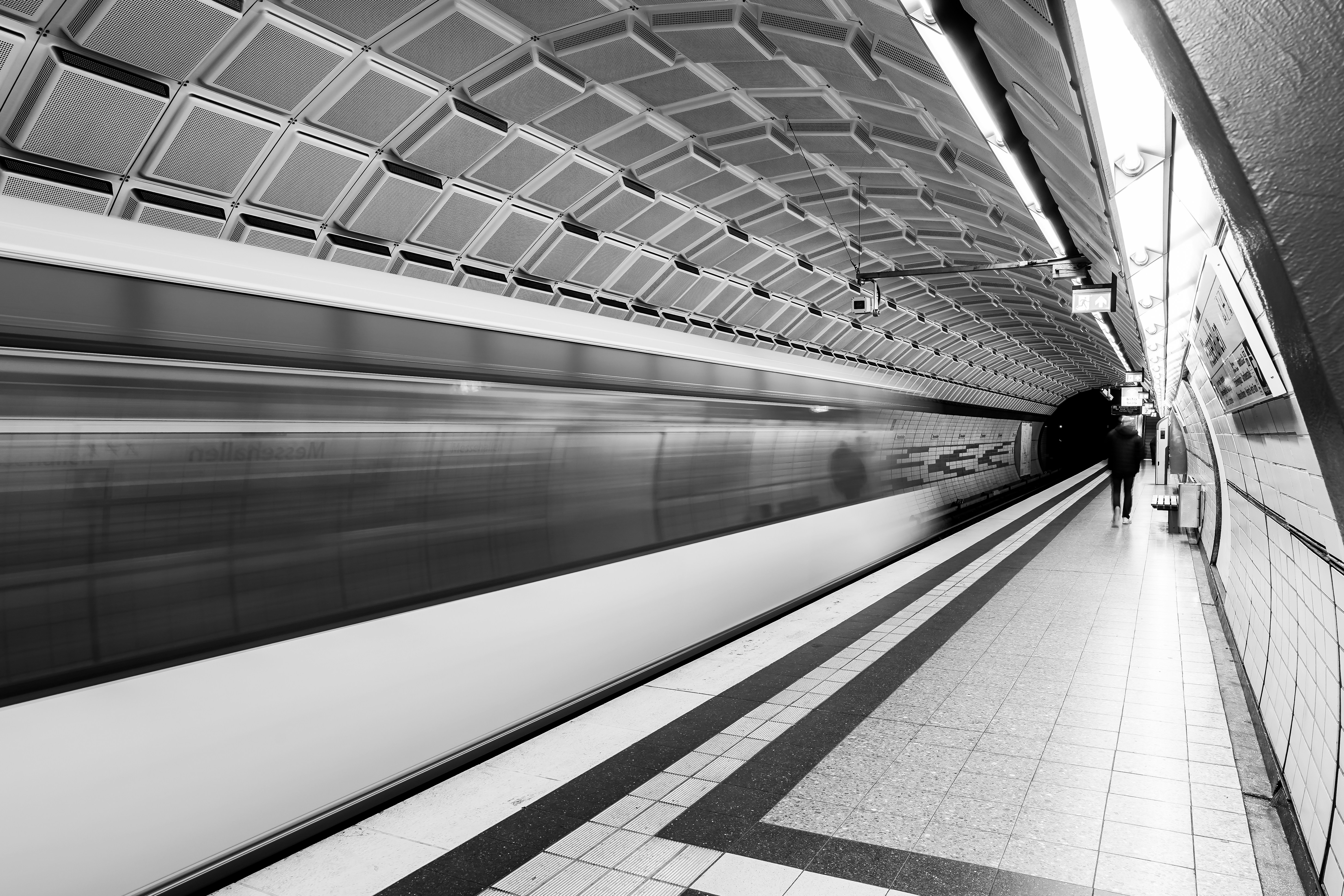 Train rushing through a modern subway station.