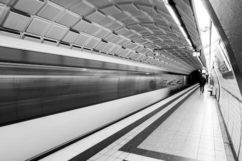 Train rushing through a modern subway station.