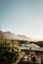People gathered at outdoor cafe with mountain backdrop