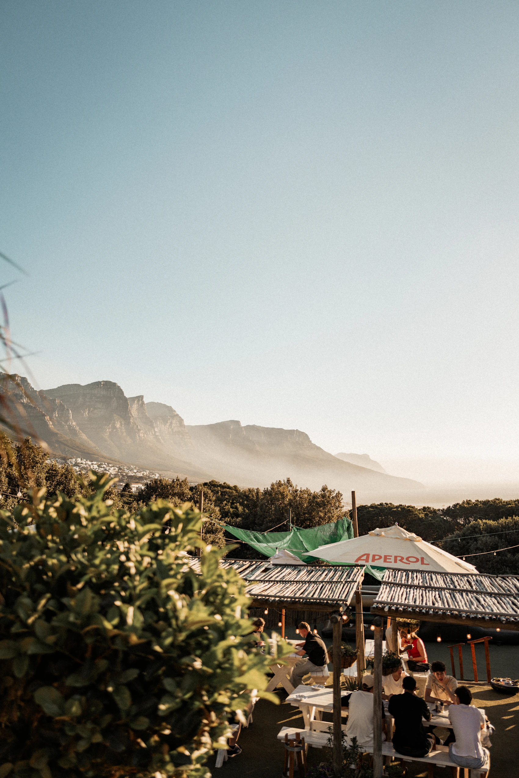 People dining outdoors beneath Table Mountain in Cape Town