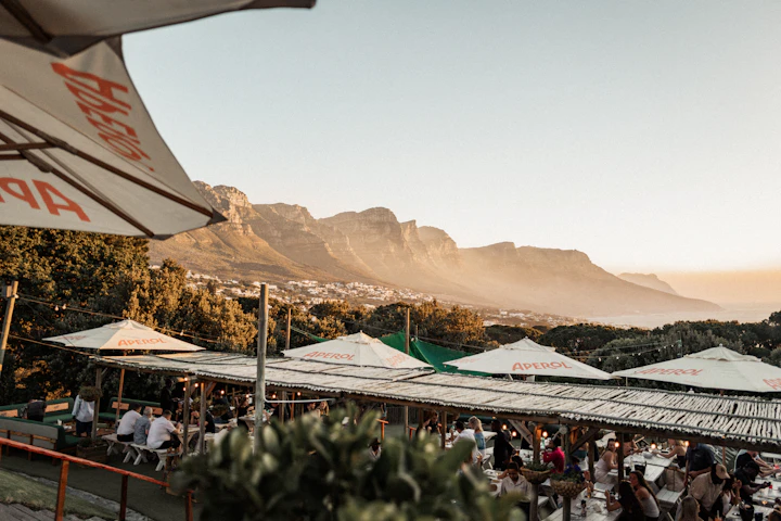 An outdoor restaurant terrace overlooking mountains at sunset