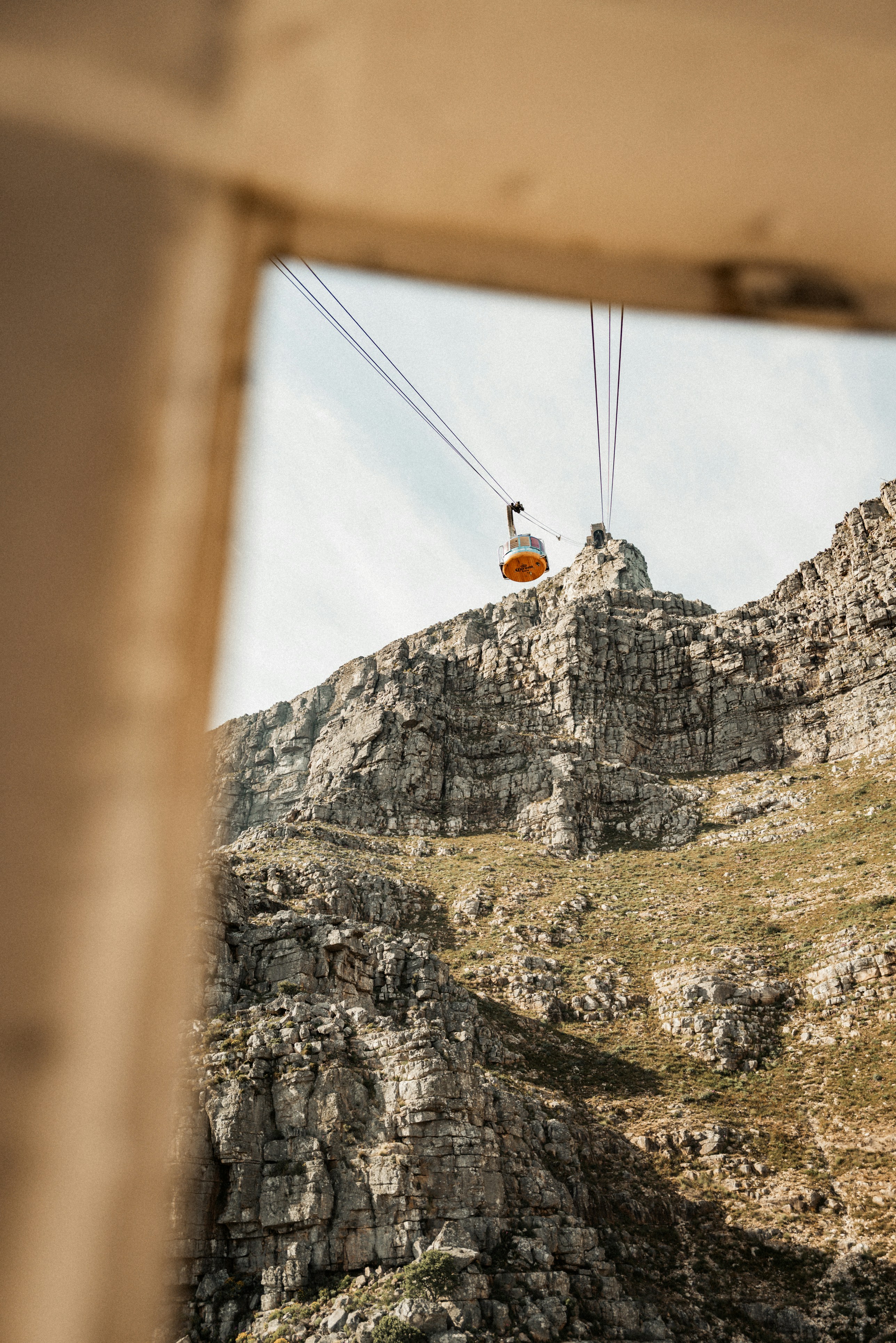 Cable car ascending rocky mountain peak