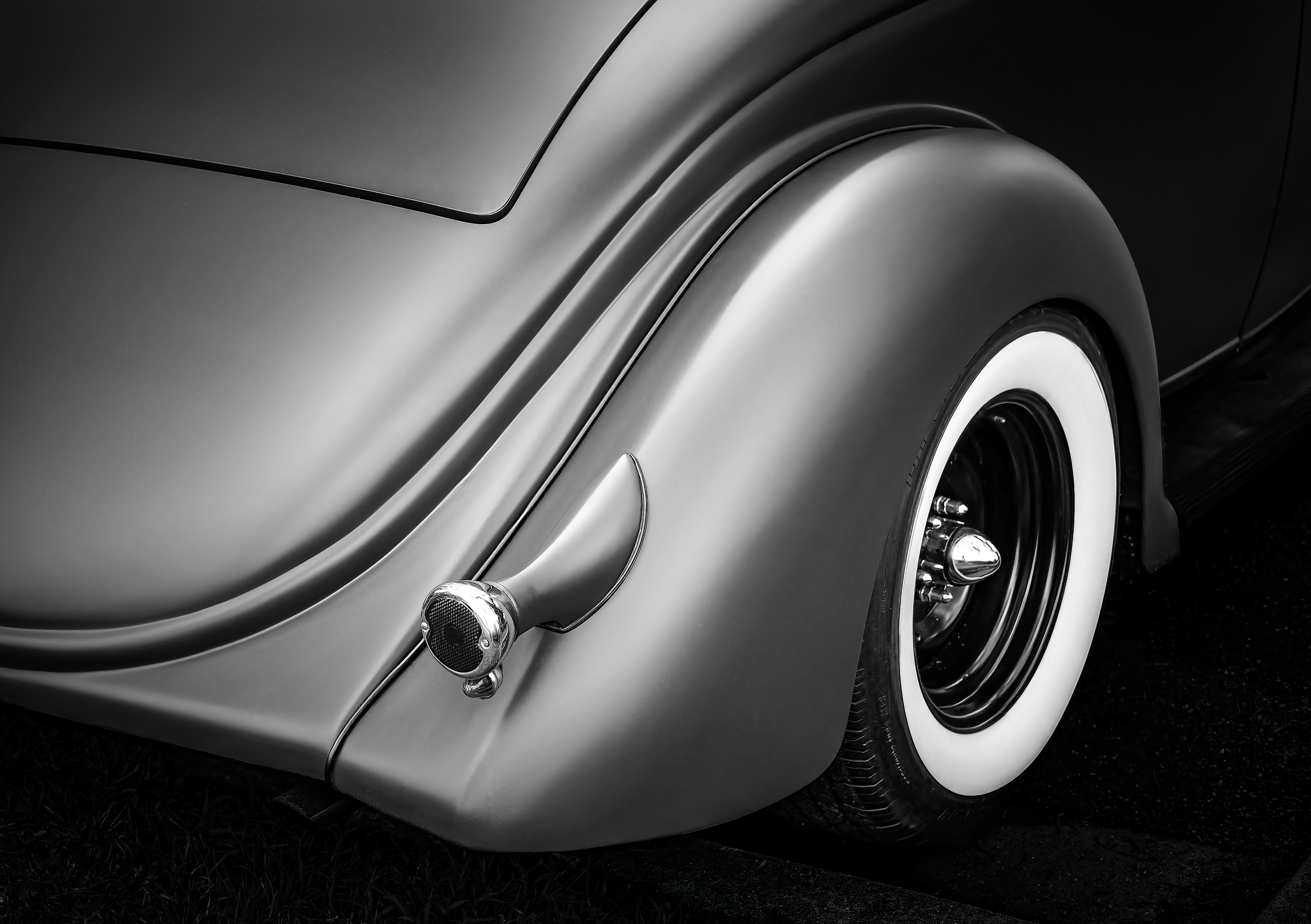 Gros plan de l’aile arrière et de la roue d’une voiture ancienne.