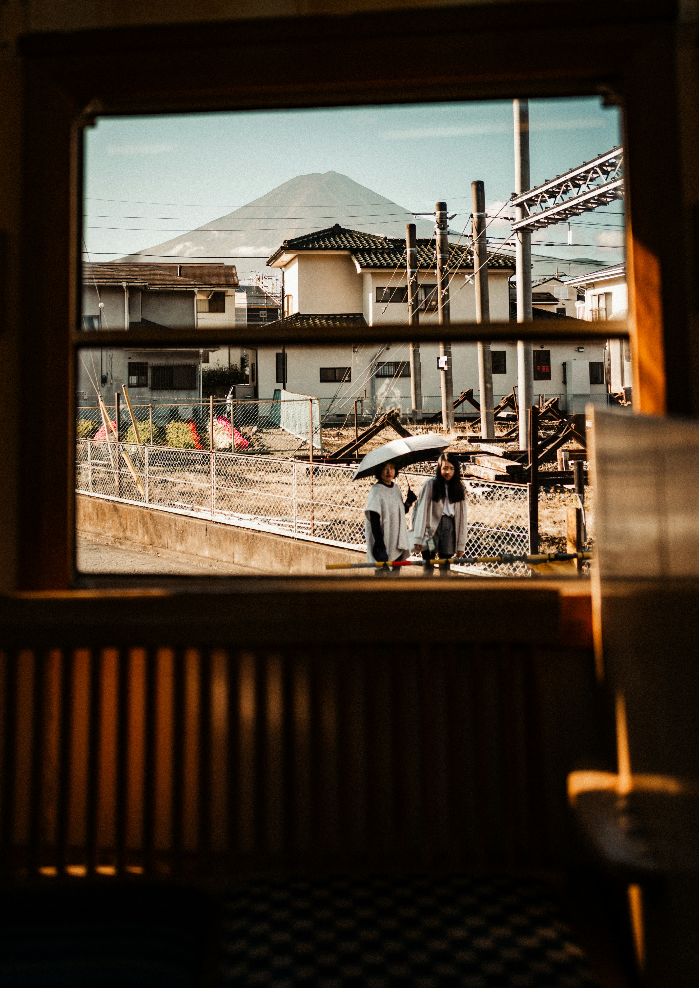 Duas pessoas caminham com guarda-chuvas perto do Monte Fuji.