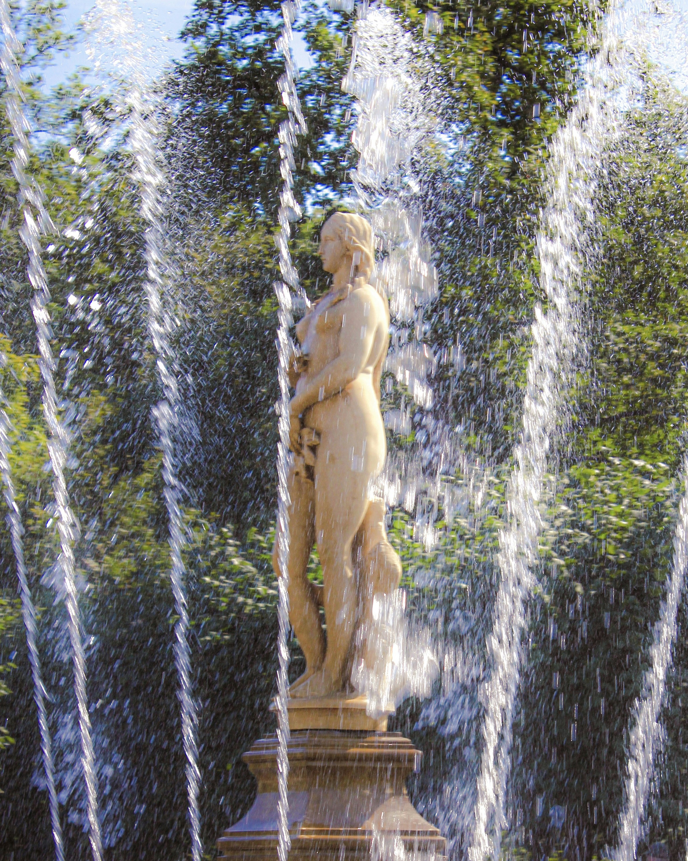 Statue surrounded by water jets in a park