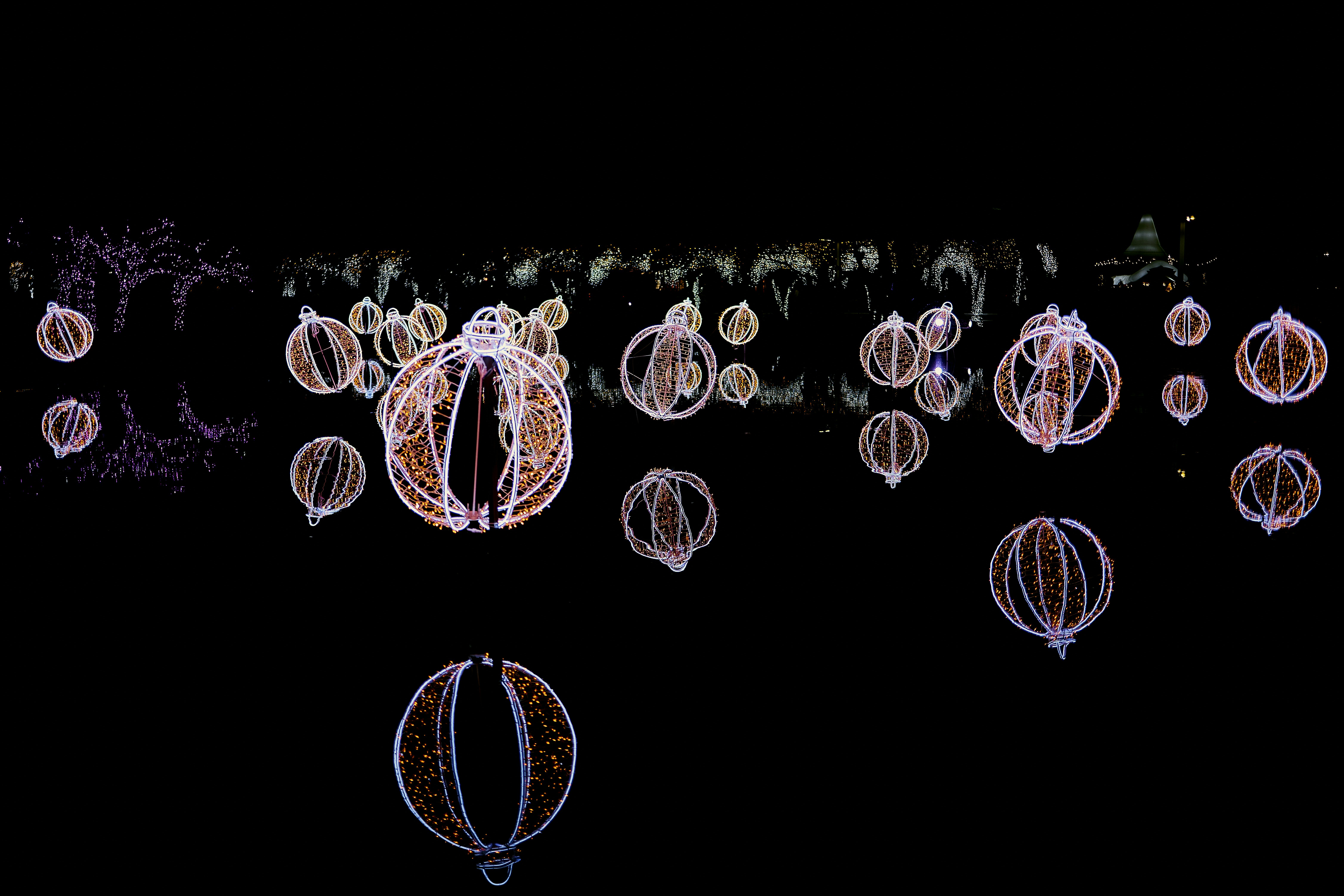 Glowing lanterns illuminate a dark night sky