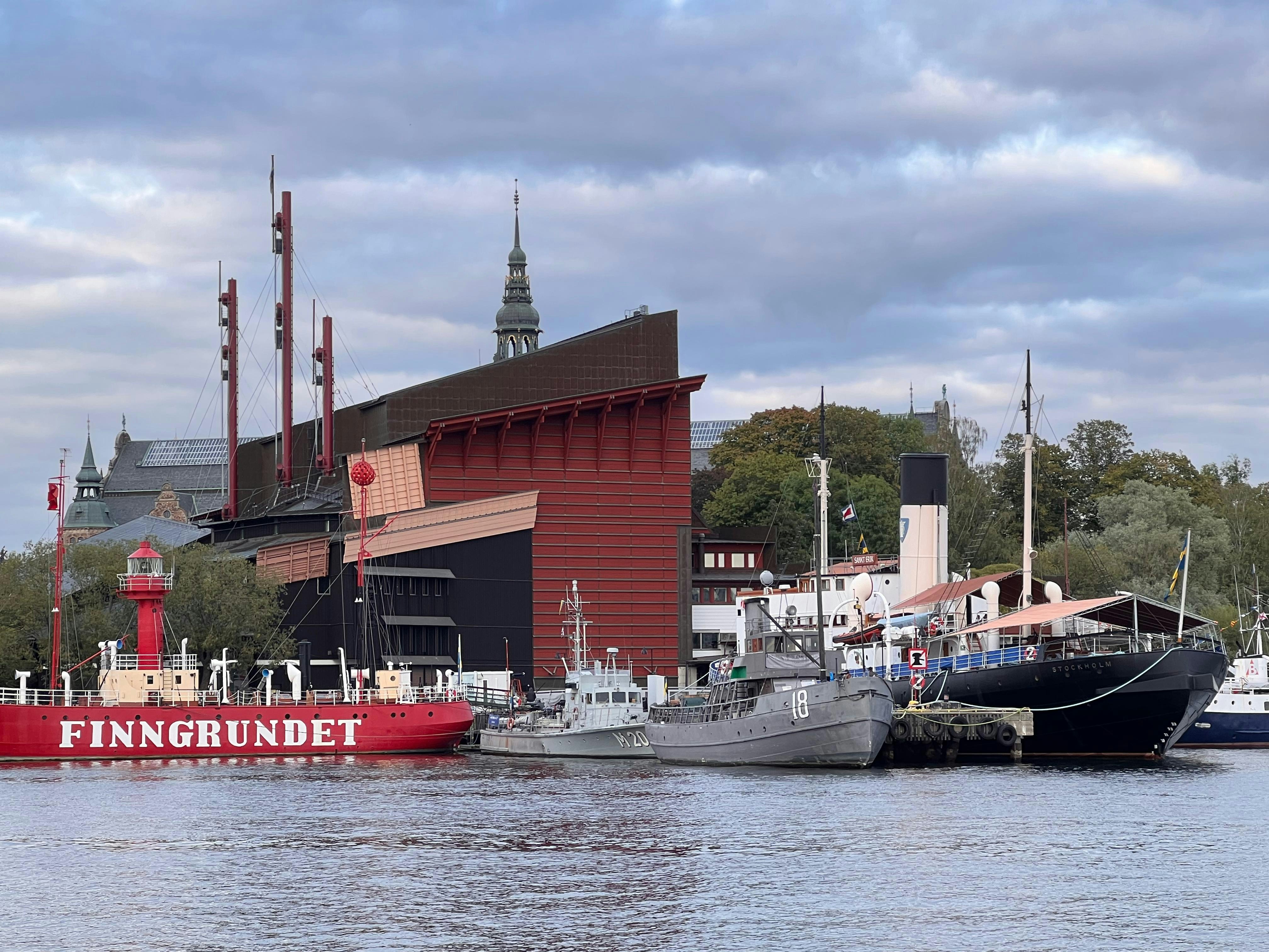 Ships docked near a red building with a spire.