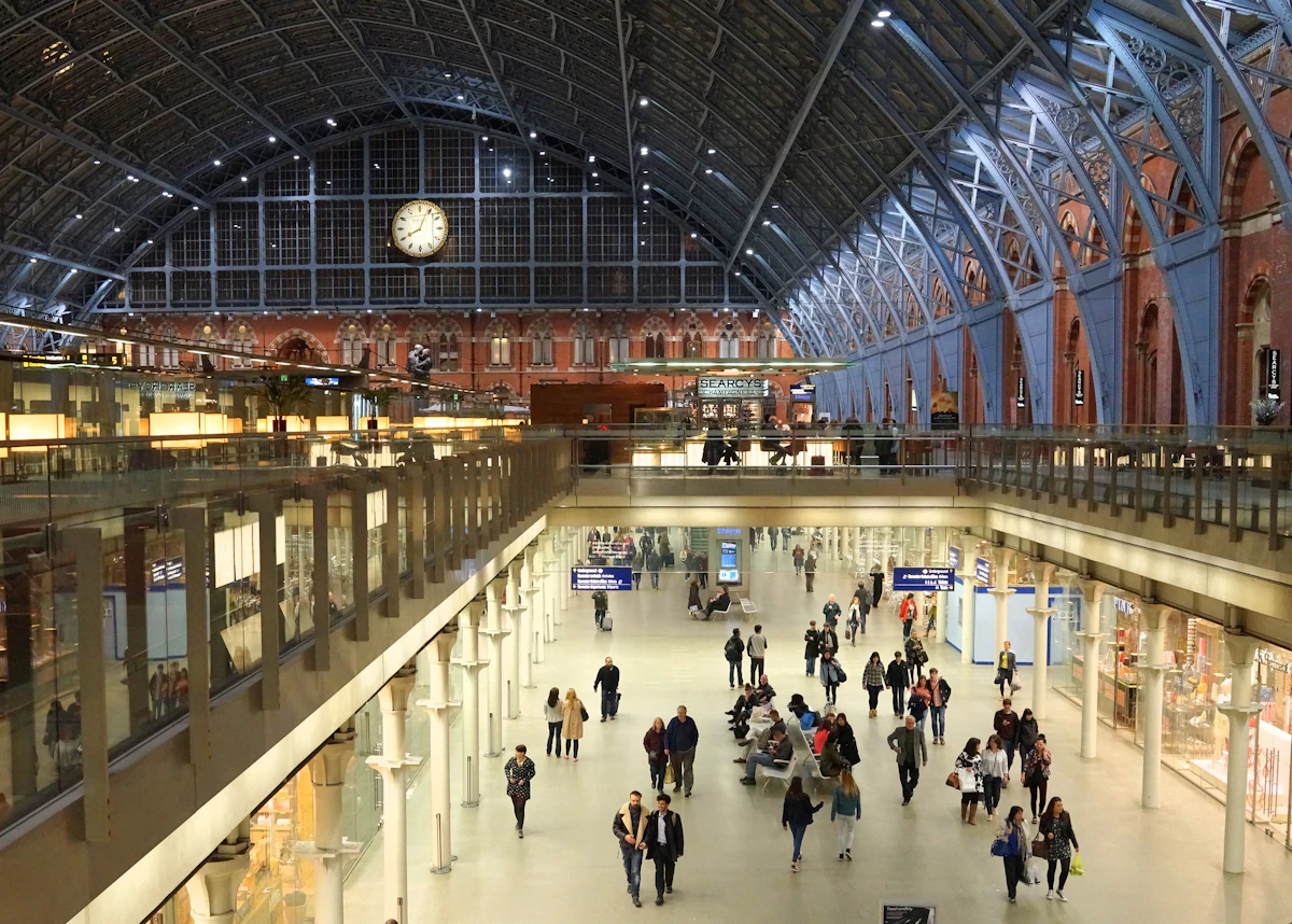 Travellers crossing a busy station concourse beneath a vast arched roof, the rail alternative to a private jet London to Paris flight